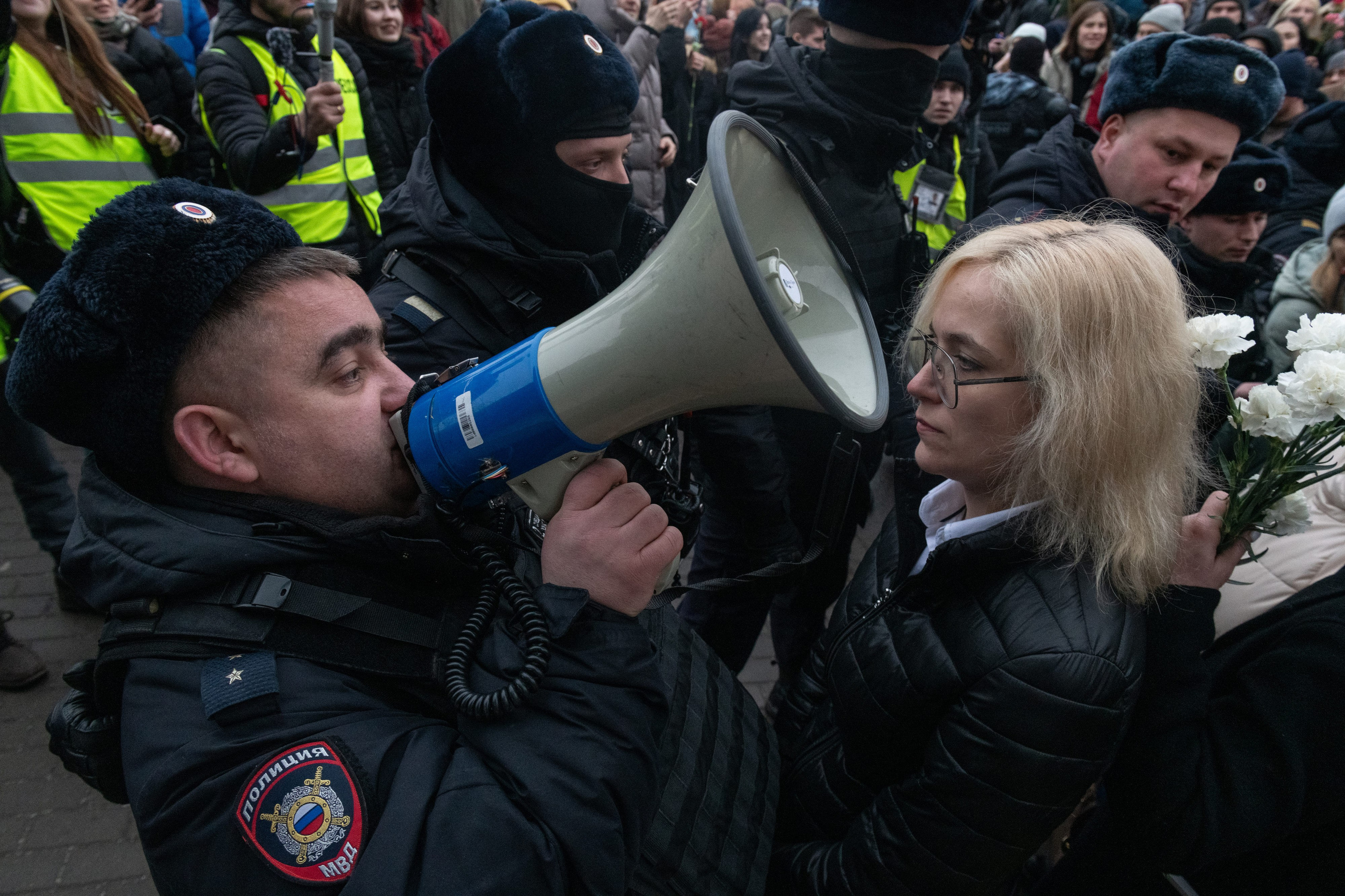 A police officer shouts through a loudspeaker during a mass march to the cemetery on the day of Alexei Navalny's funeral. Moscow, March 1, 2024.
