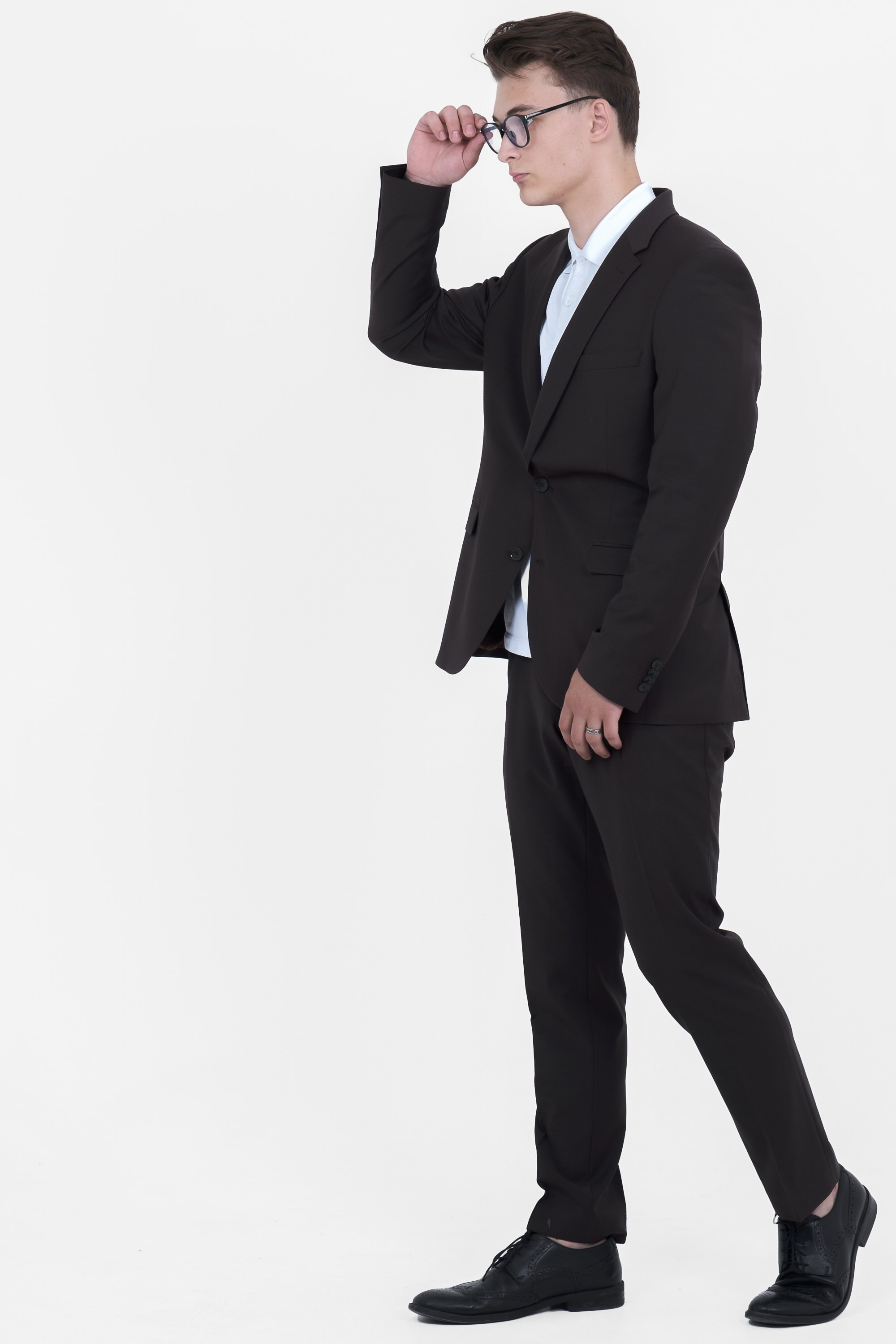 Молодой человек в чёрном костюме в очках и ботинках.  Фото для маркетплейсов