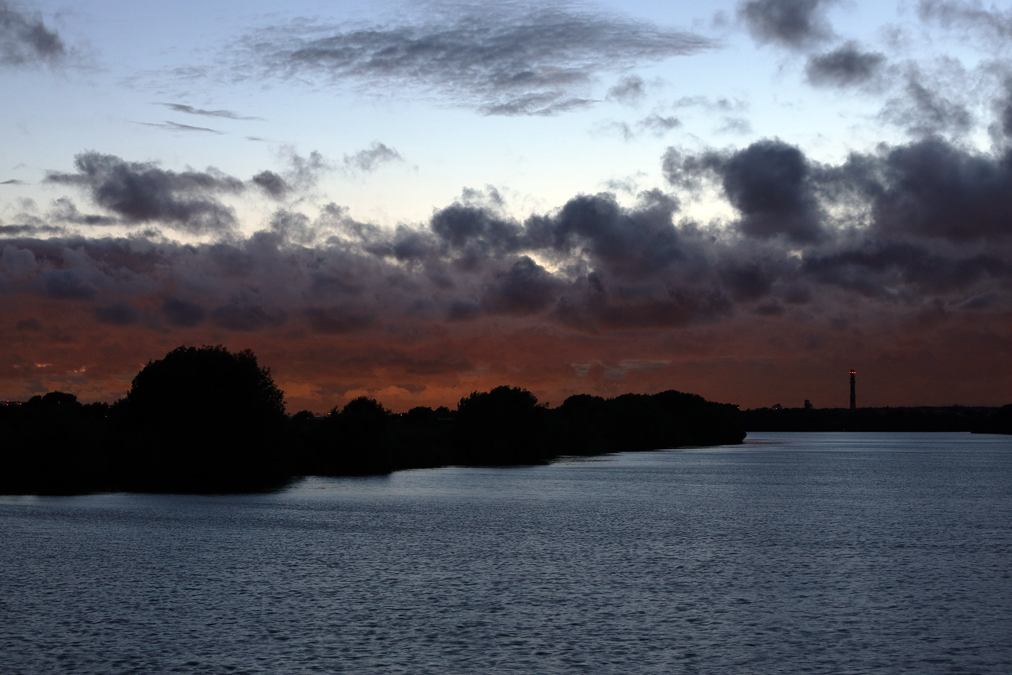 Багряный закат в грозу летом на реке Москва