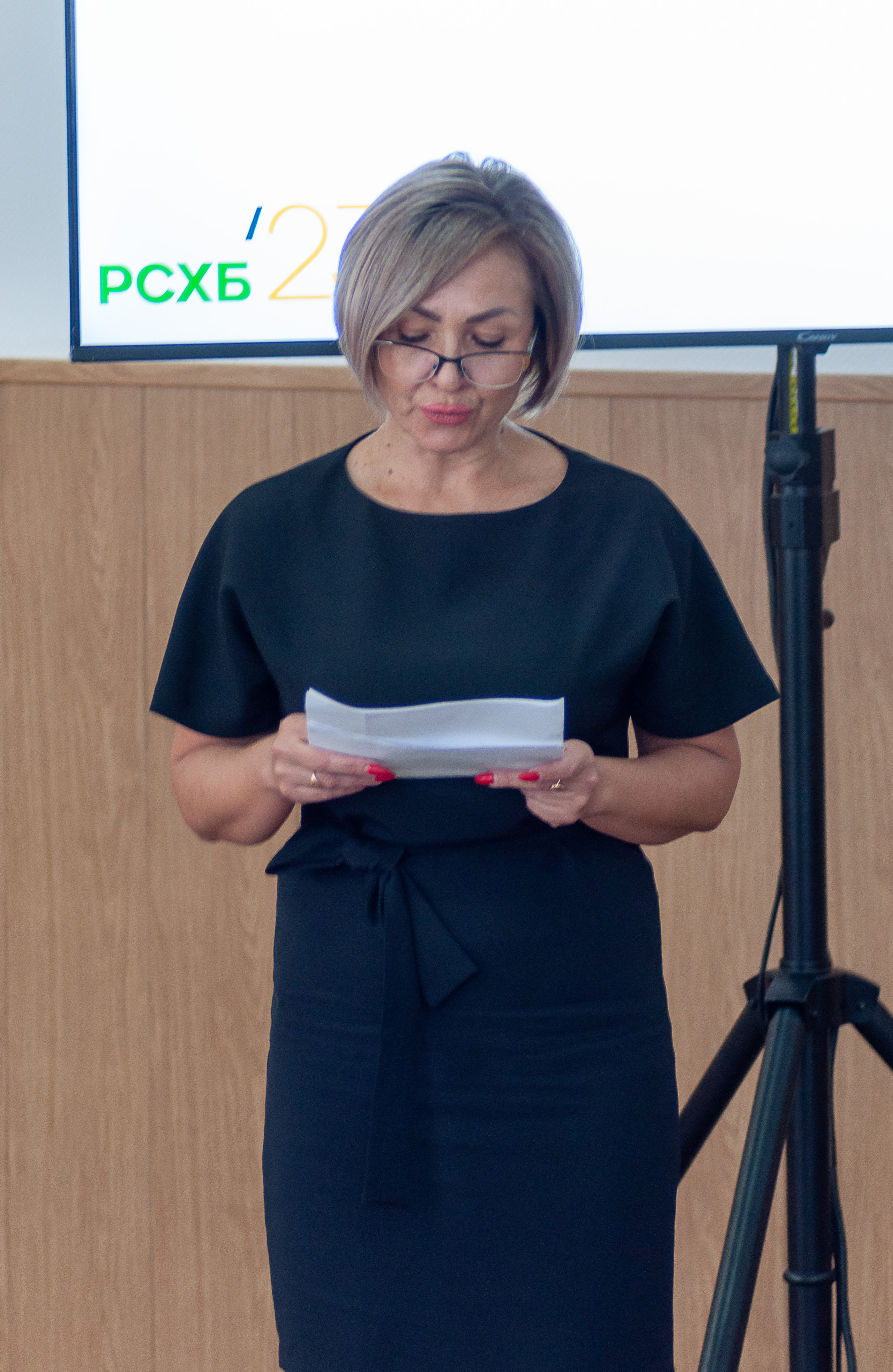 Женщина проводит презентацию по теме сельской ипотеки на фоне экрана Россельхозбанка.