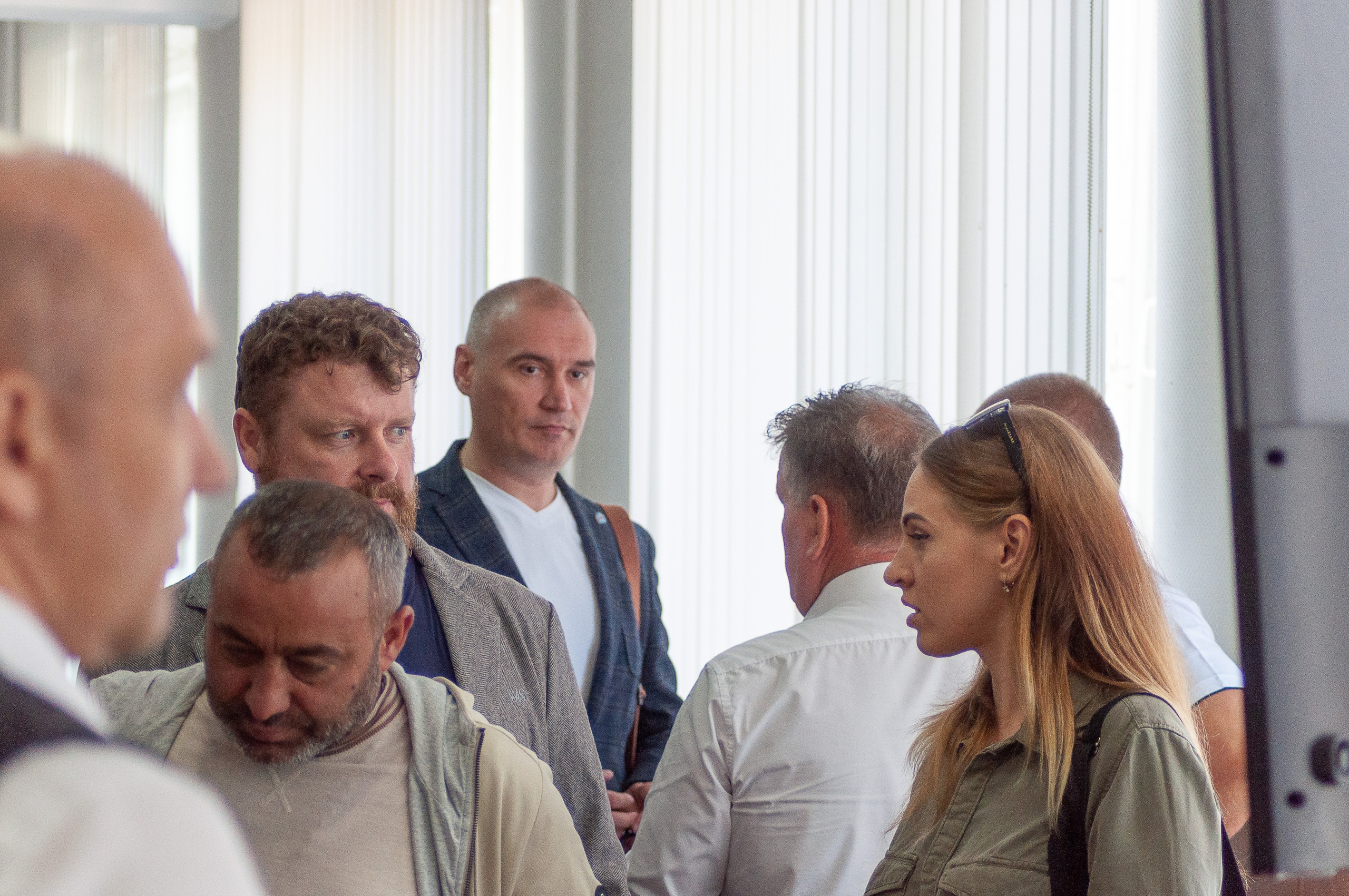 Участники обсуждают итоги деловой встречи в холле конференц-зала после завершения выступлений.