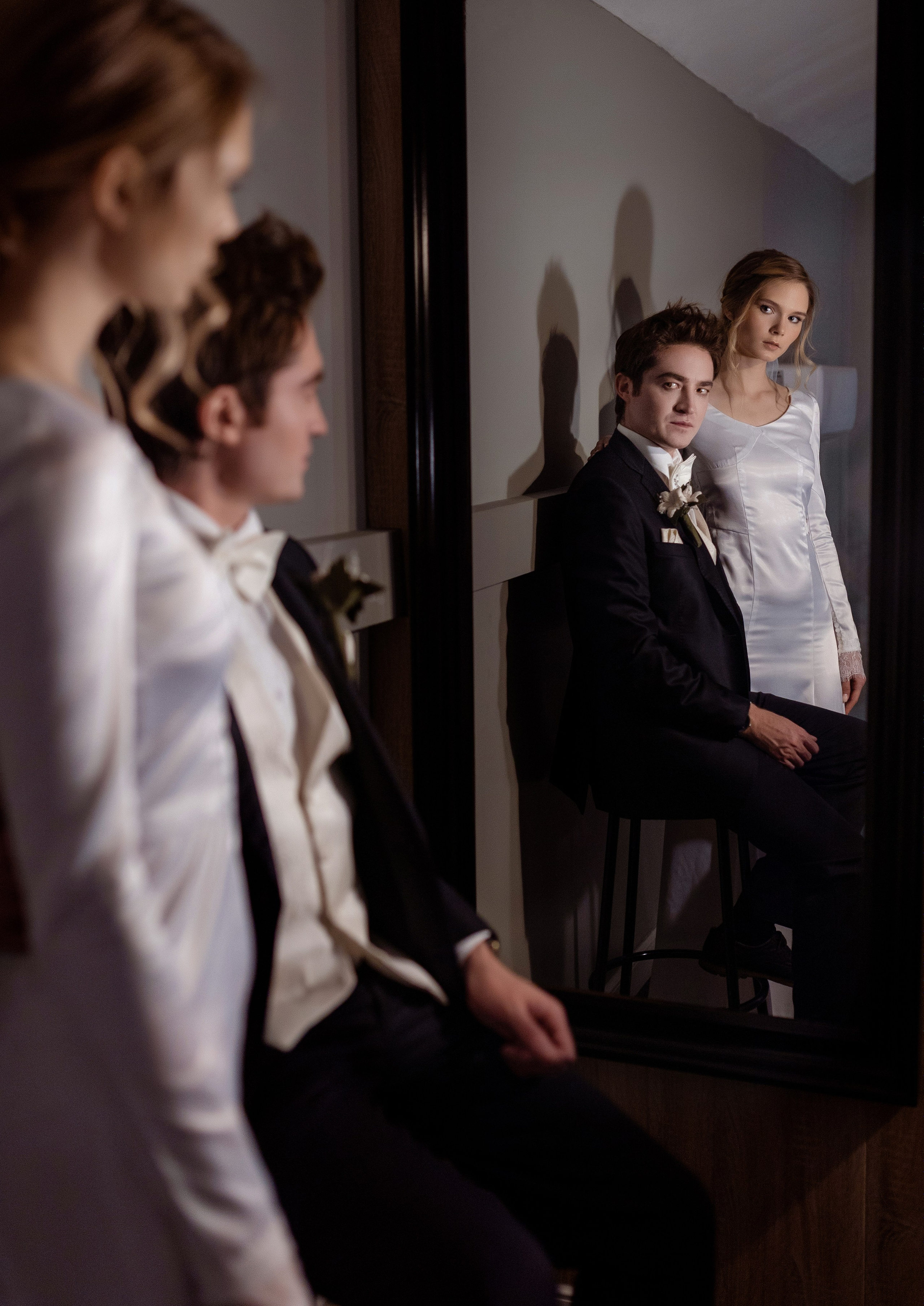 Жених и невеста вместе у зеркала смотрят на свое отображение.