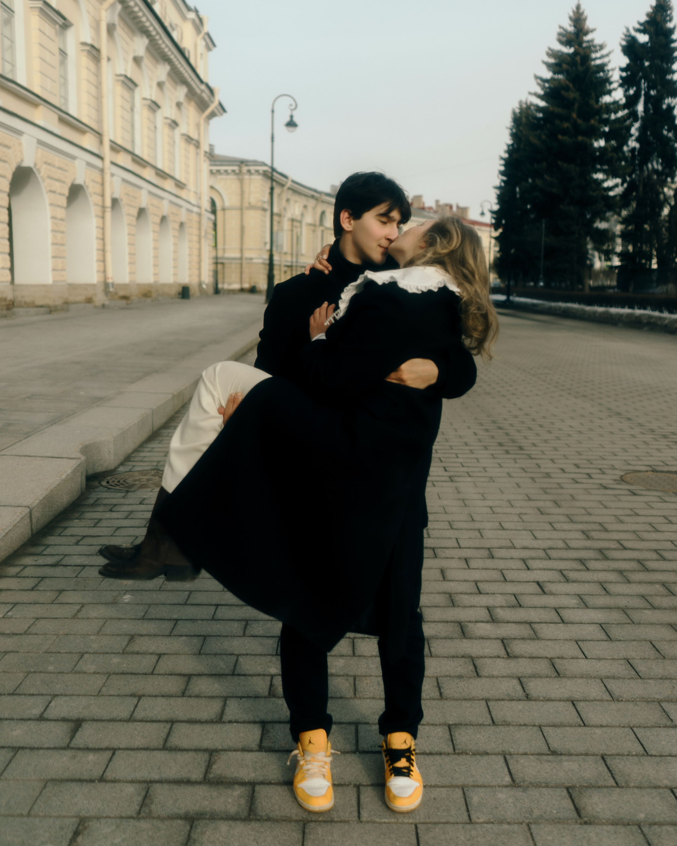 Фотосессия пары на городской улице, мужчина держит девушку на руках, авторская love story съемка в Петербурге с художественной подачей