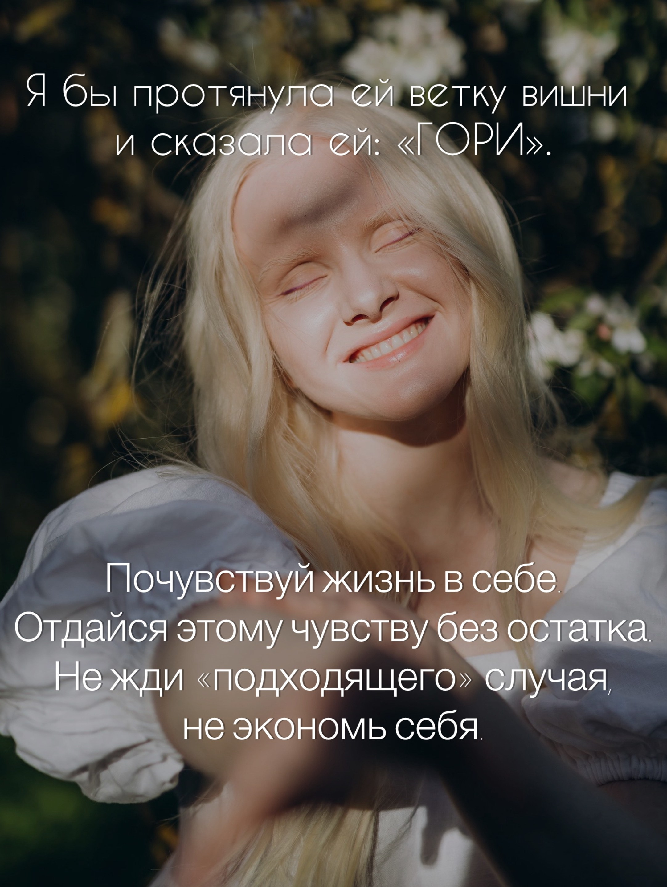 Крупный портрет лица — женщина с закрытыми глазами и улыбкой на фоне цветущих веток