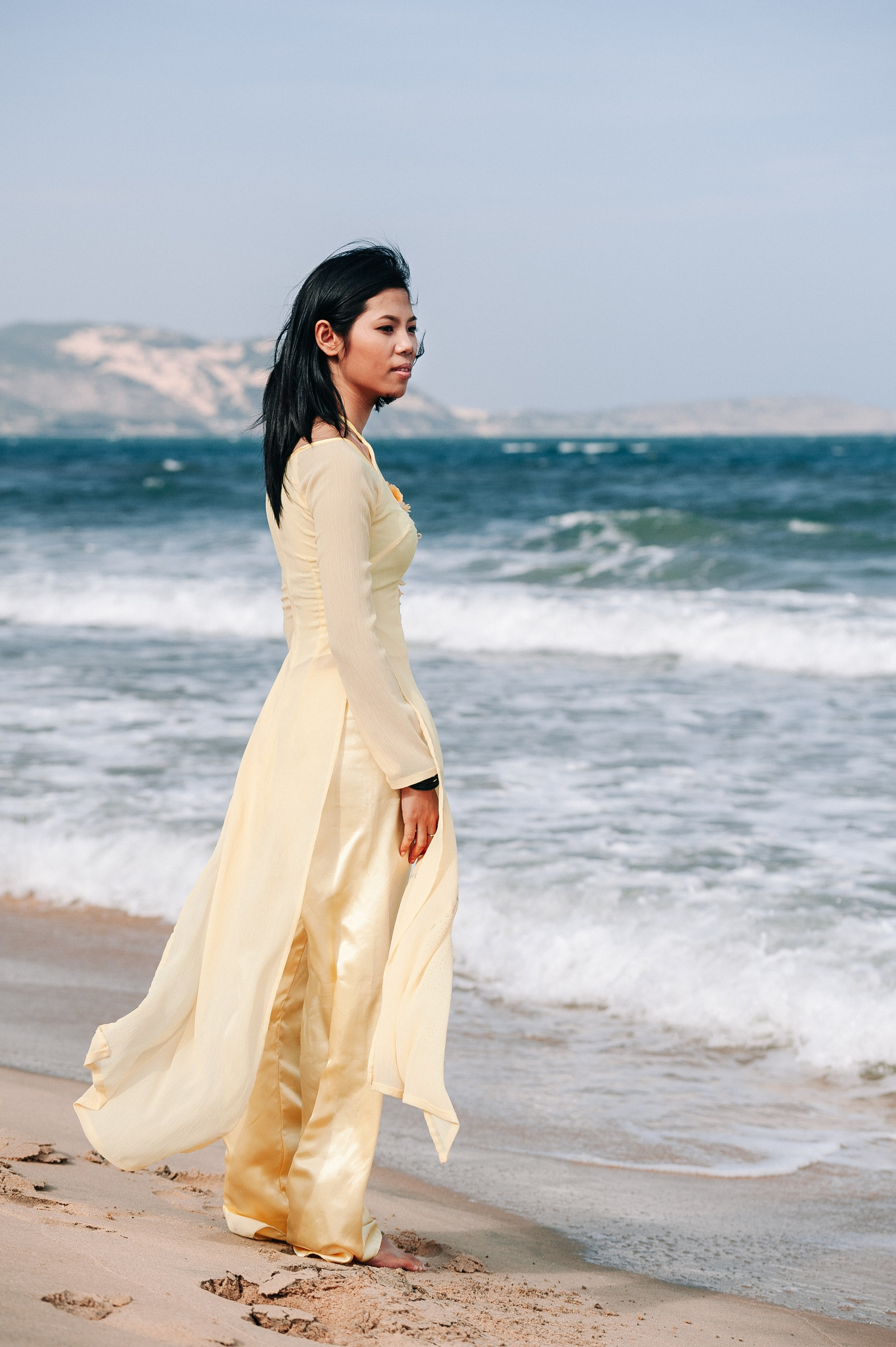 Фотосессия вьетнамской девушки в традиционном вьетнамском костюме Аозай золотого цвета, на пляже Муине, Вьетнам 