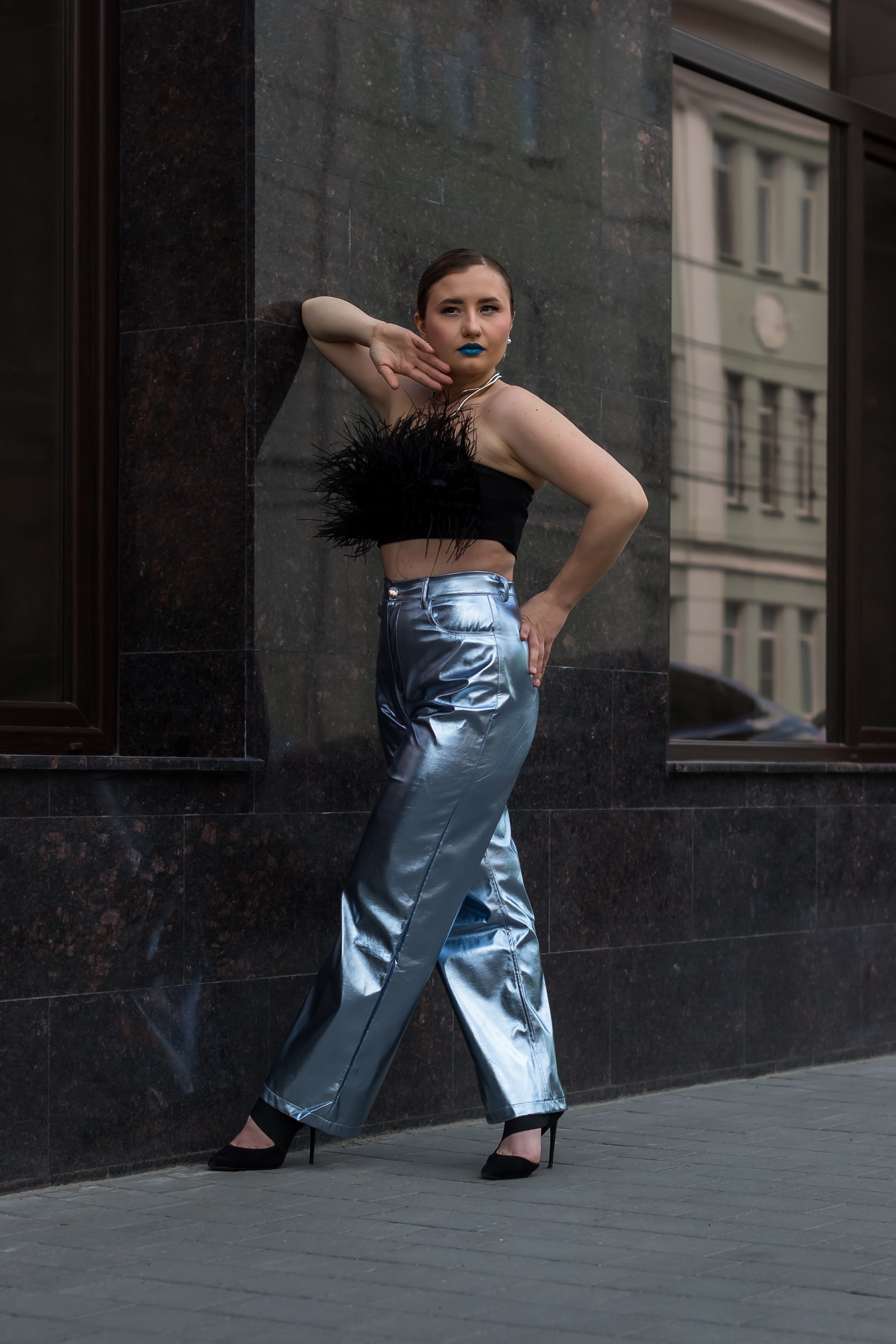 Портрет девушки на улице около стены.