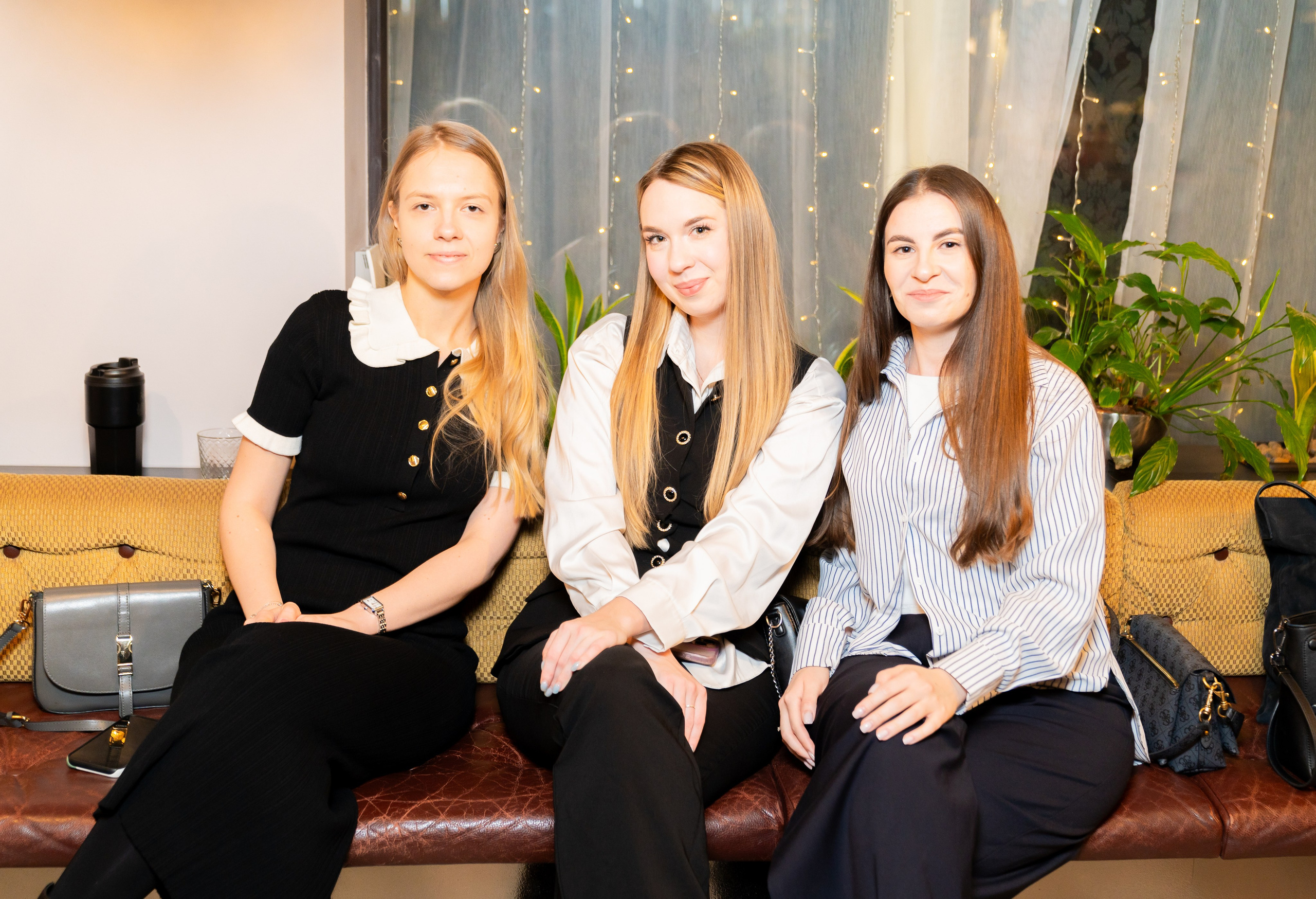 Три девушки сидят на кожаном диване и позируют на корпоративном вечере в Radisson Sonya. Фото Евгения Мальцева (evrednix.ru).