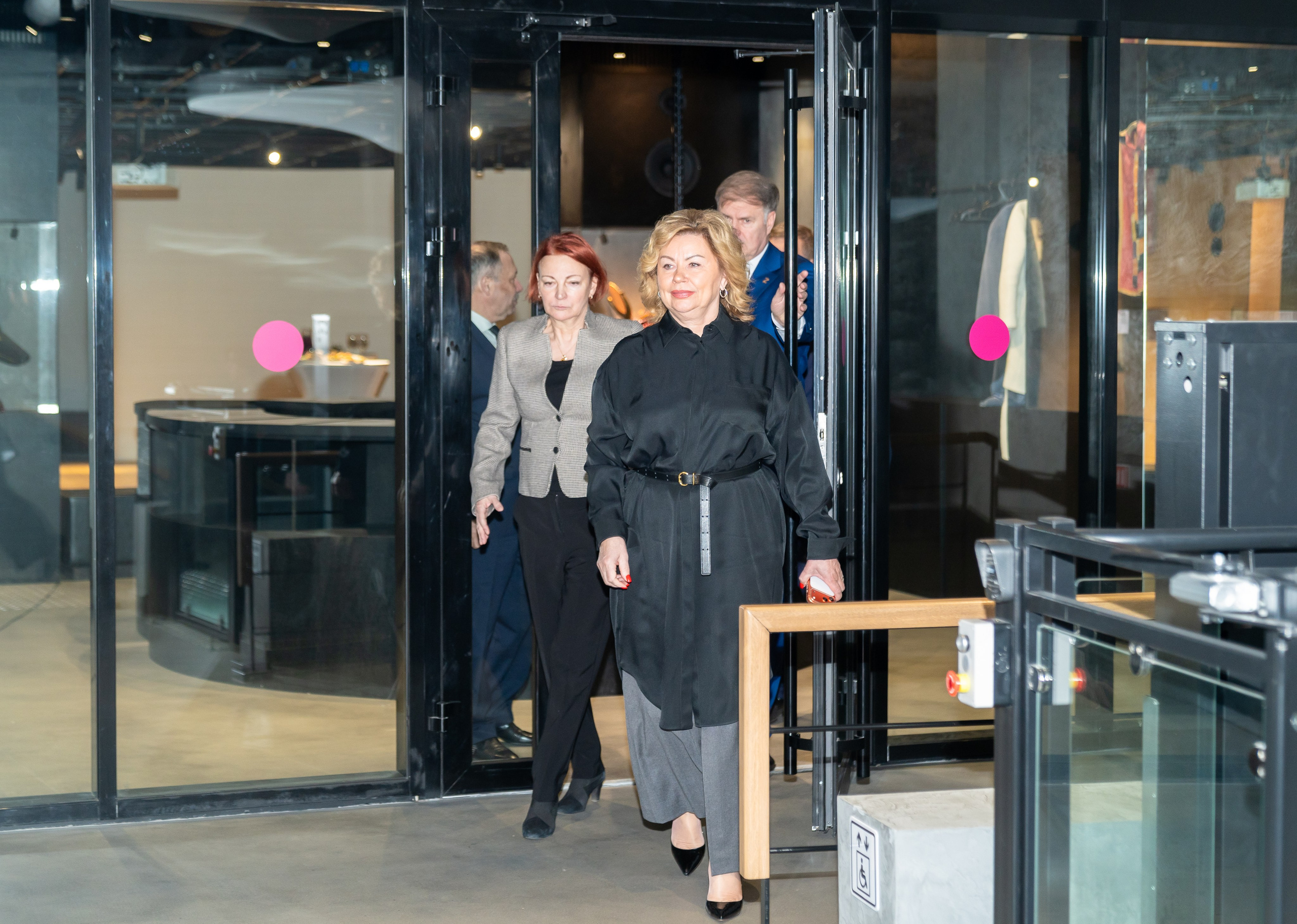 Прибытие гостей на мероприятие День местного самоуправления Санкт-Петербург. Женщины в строгих образах проходят через стеклянные двери. Фото Евгения Мальцева.