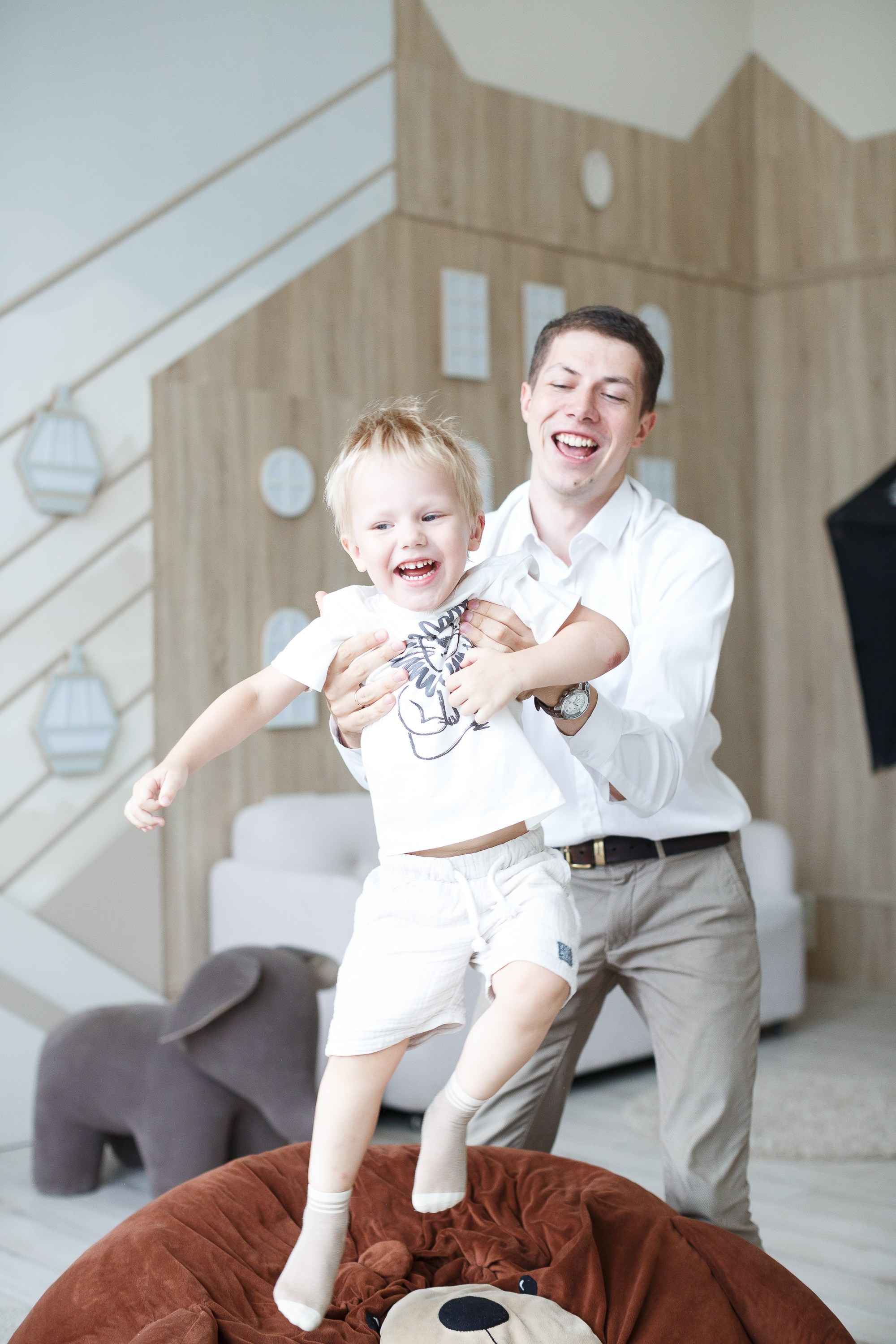 Папа подбрасывает ребенка. Семейная фотосессия в студии.