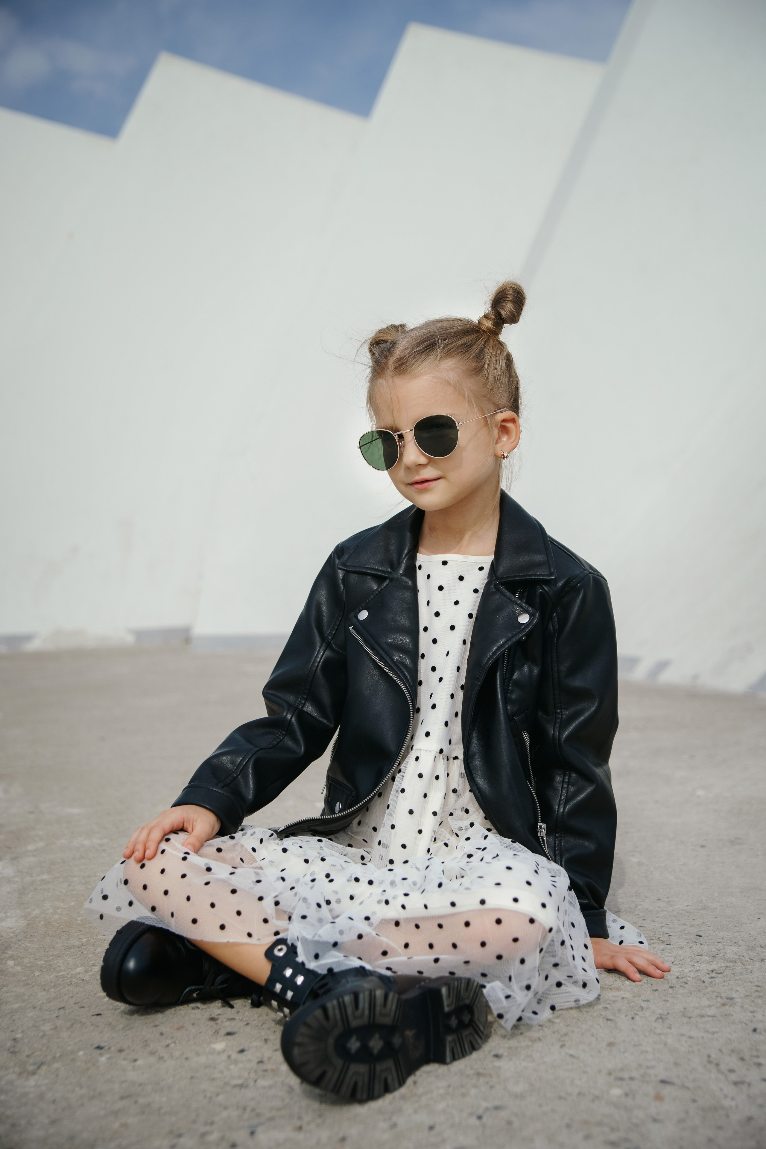 Детская фотосессия летом - девочка сидя в кожаной куртке