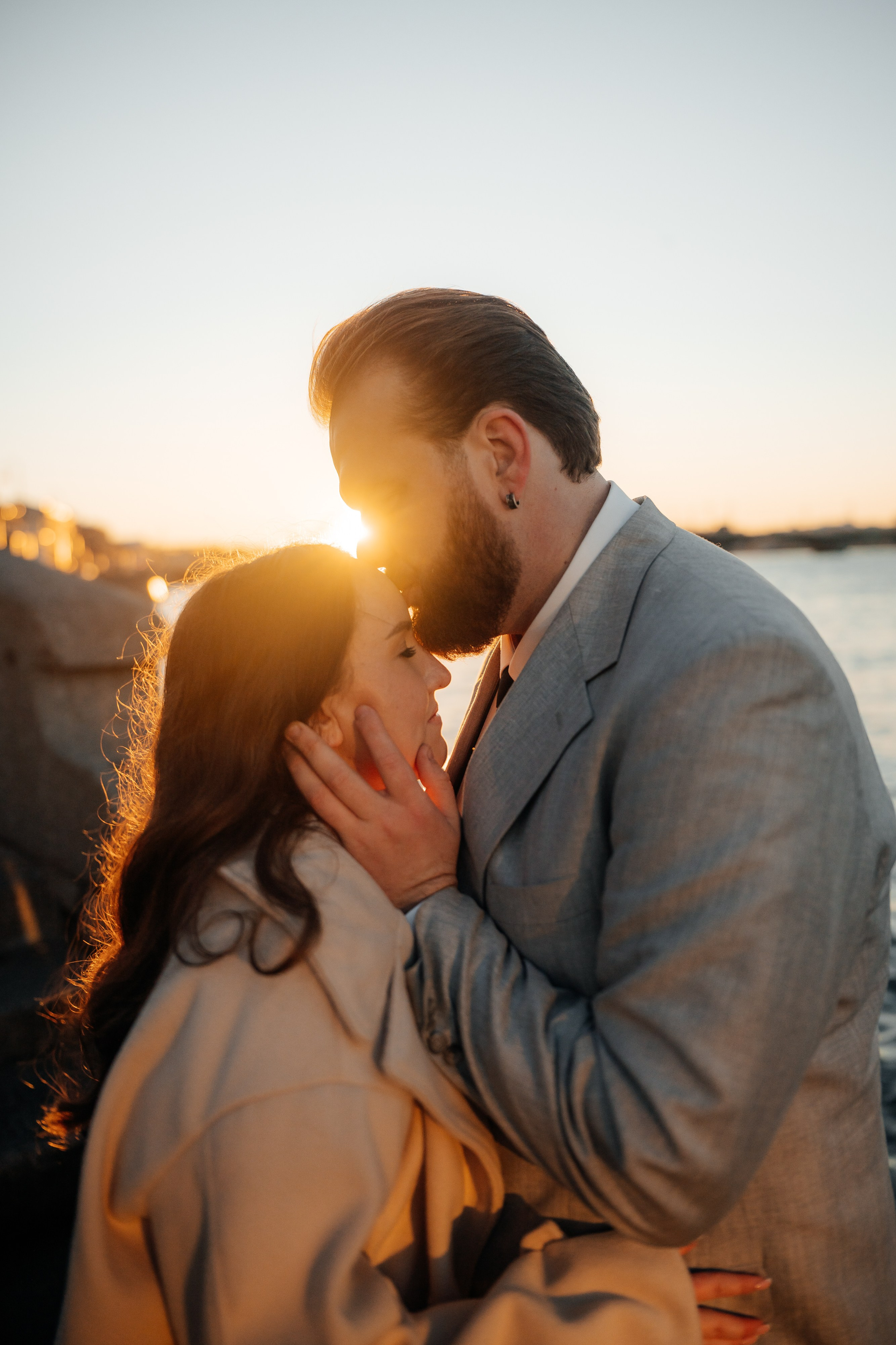 Свадебная фотосессия на закате осенью жених и невеста обнимаются на набережной в лучах солнца
