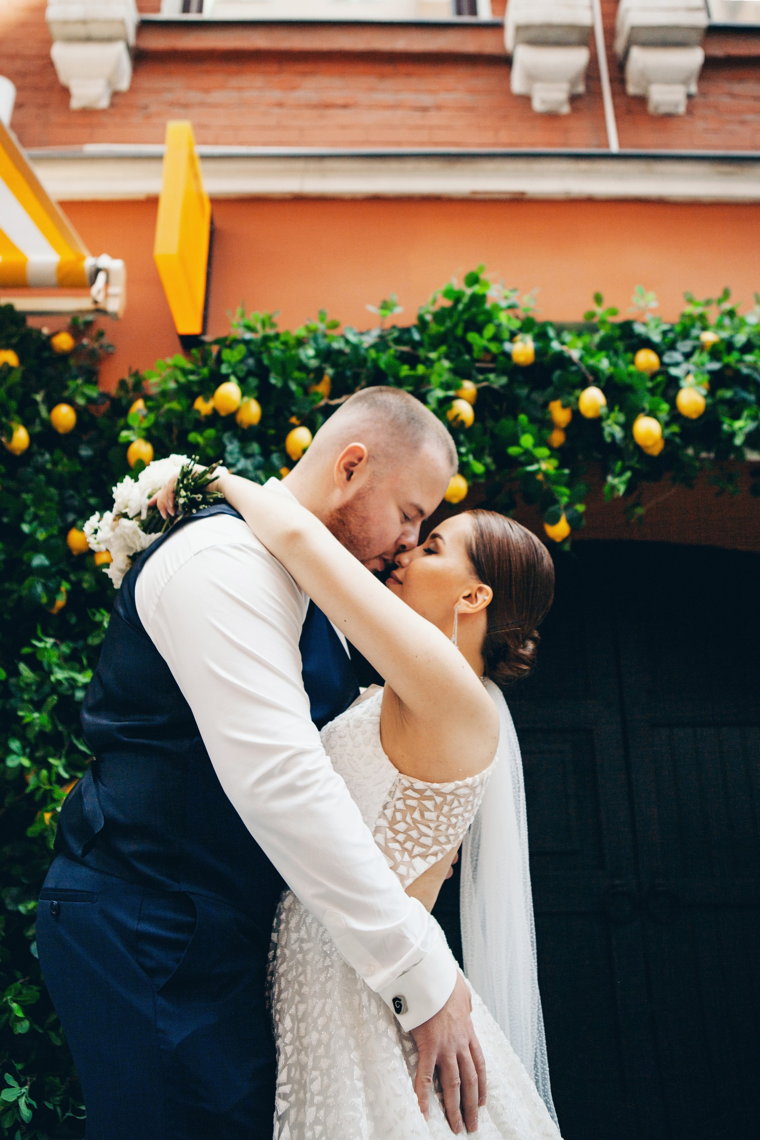 жених и невеста целуются на фоне лимонов