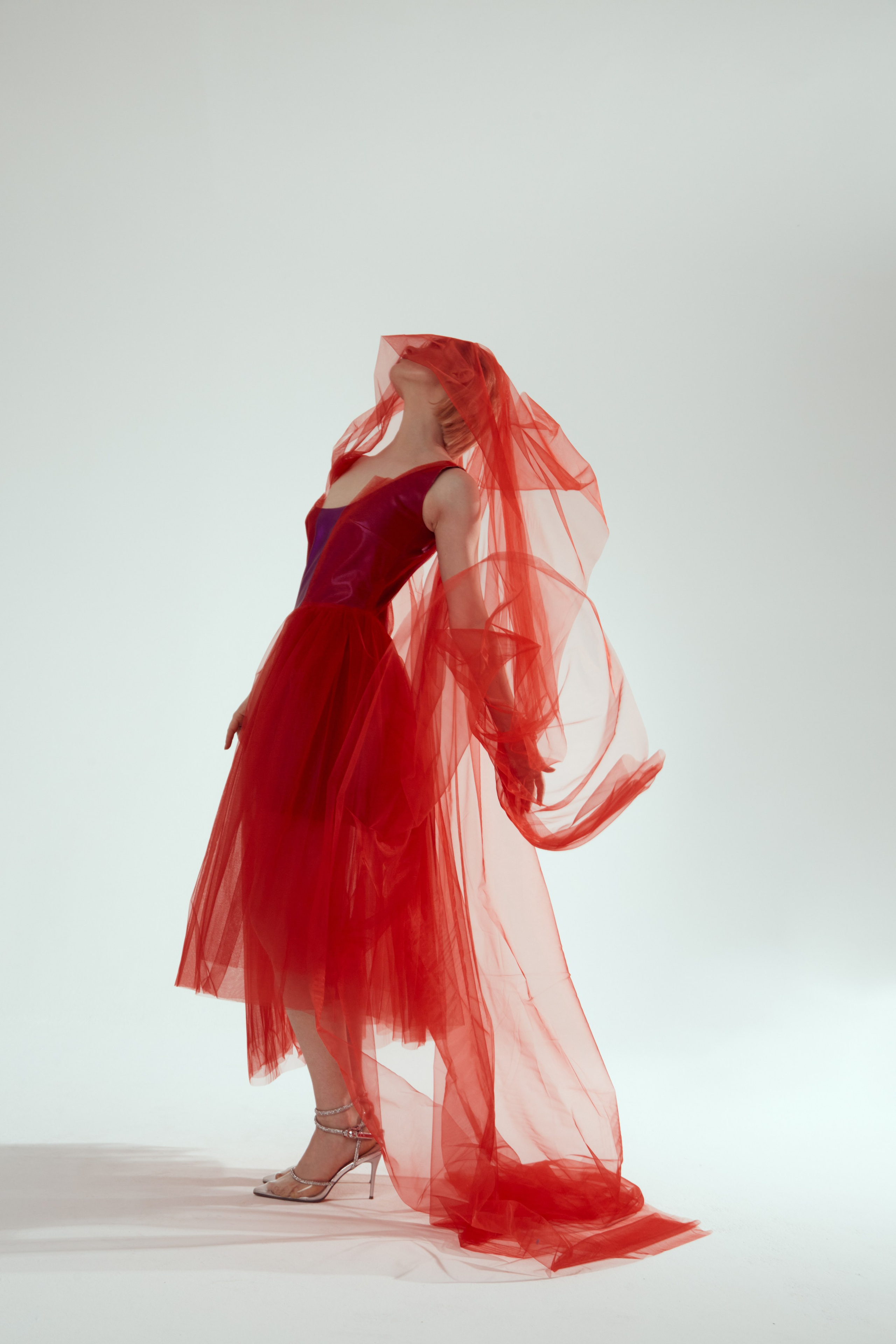 Девушка в красном платье красиво запрокинула голову