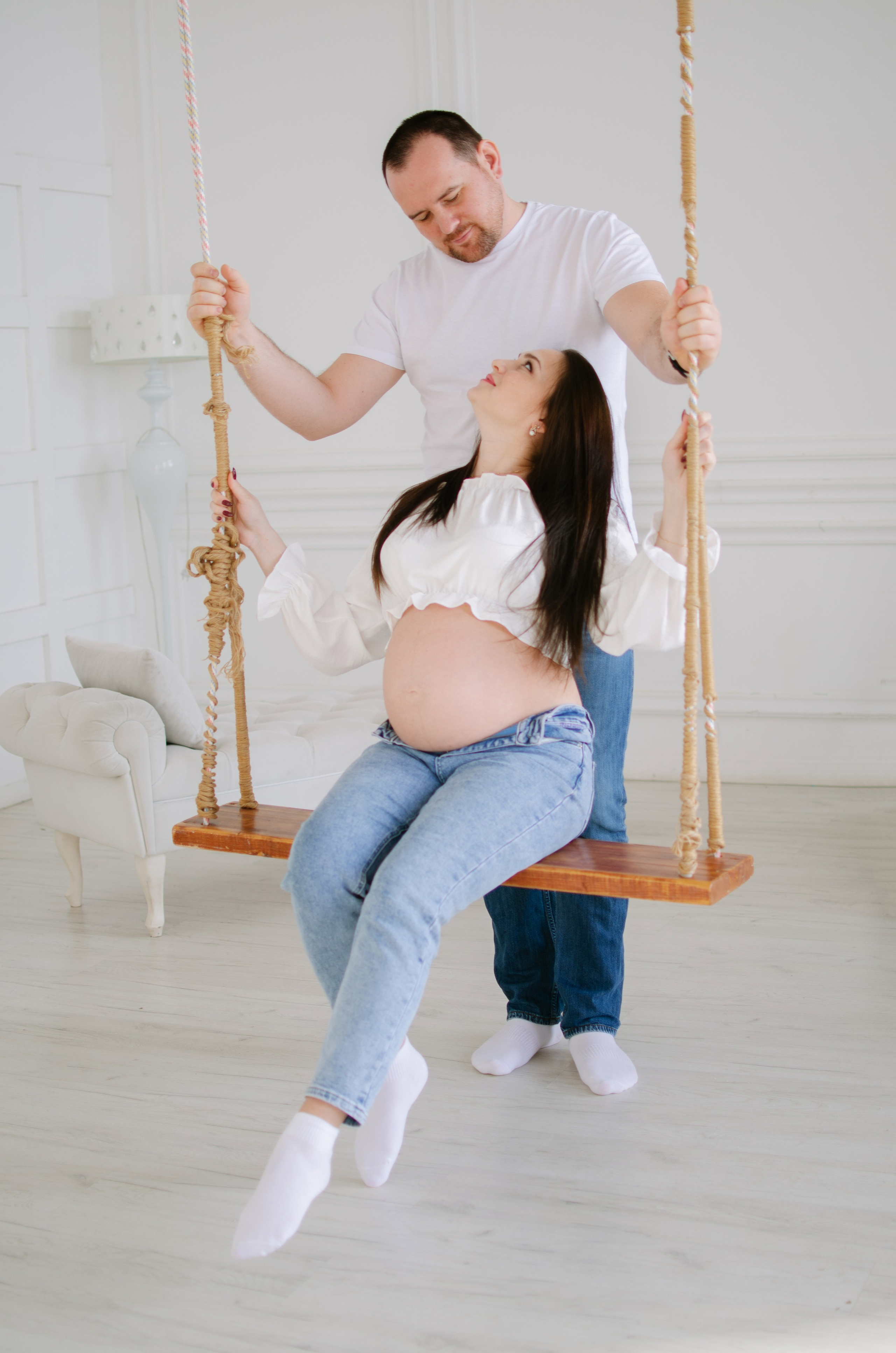 Муж и жена на качелях в фотостудии