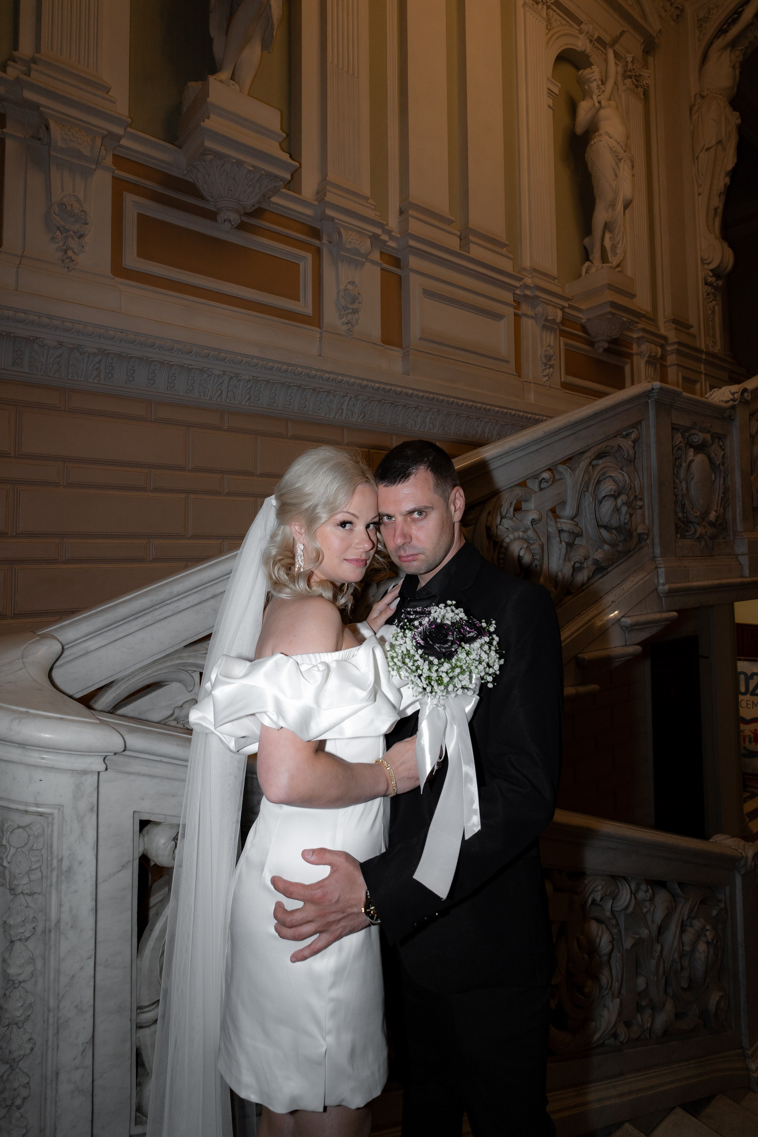 жених и невеста обнимаются на главной лестнице дворца бракосочетания №1 