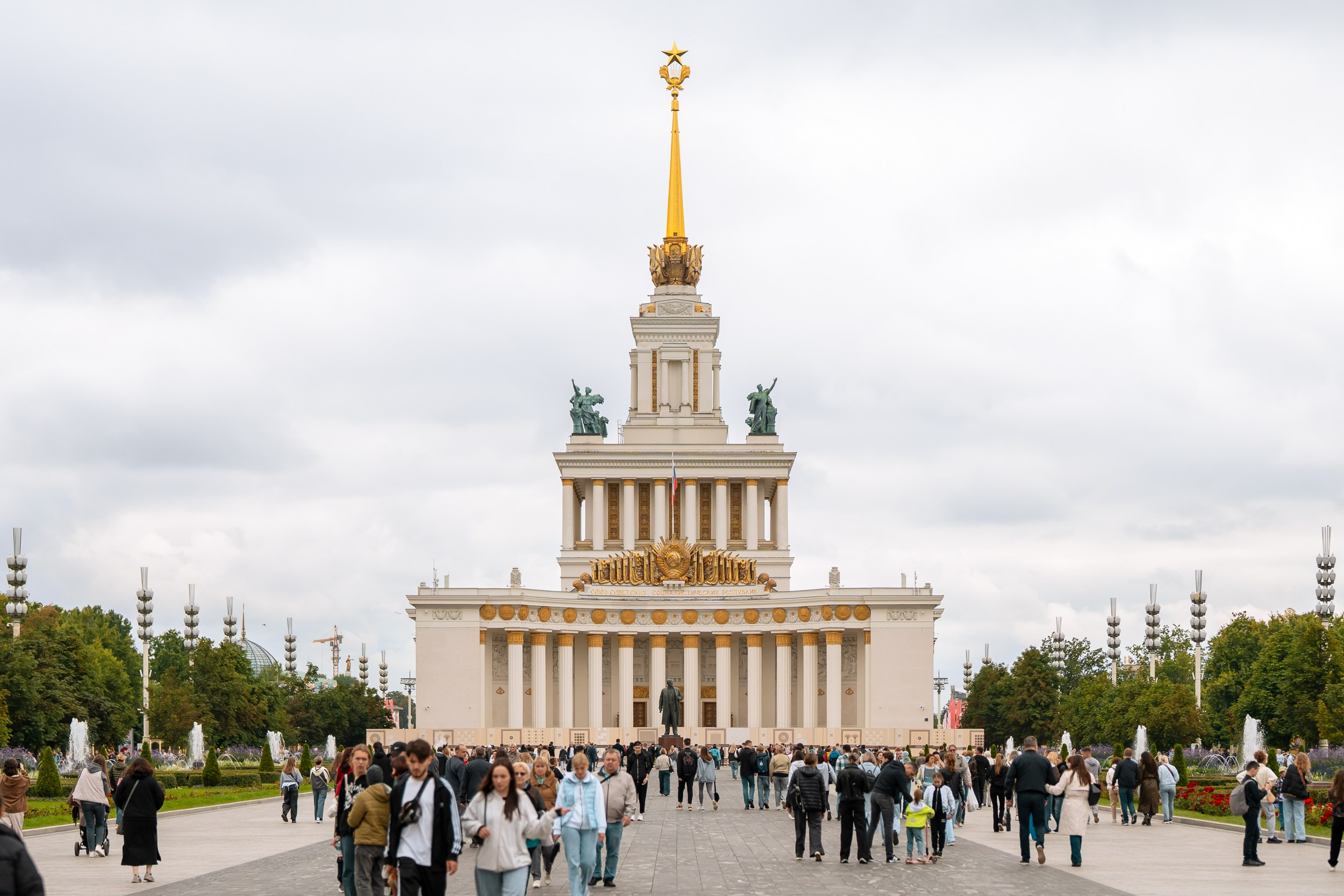 Главный павильон ВДНХ в Москве во время фестиваля «Вкусы России 2025». Репортажная фотография от казанского фотографа, посетители гуляют по аллее перед выставочным комплексом.