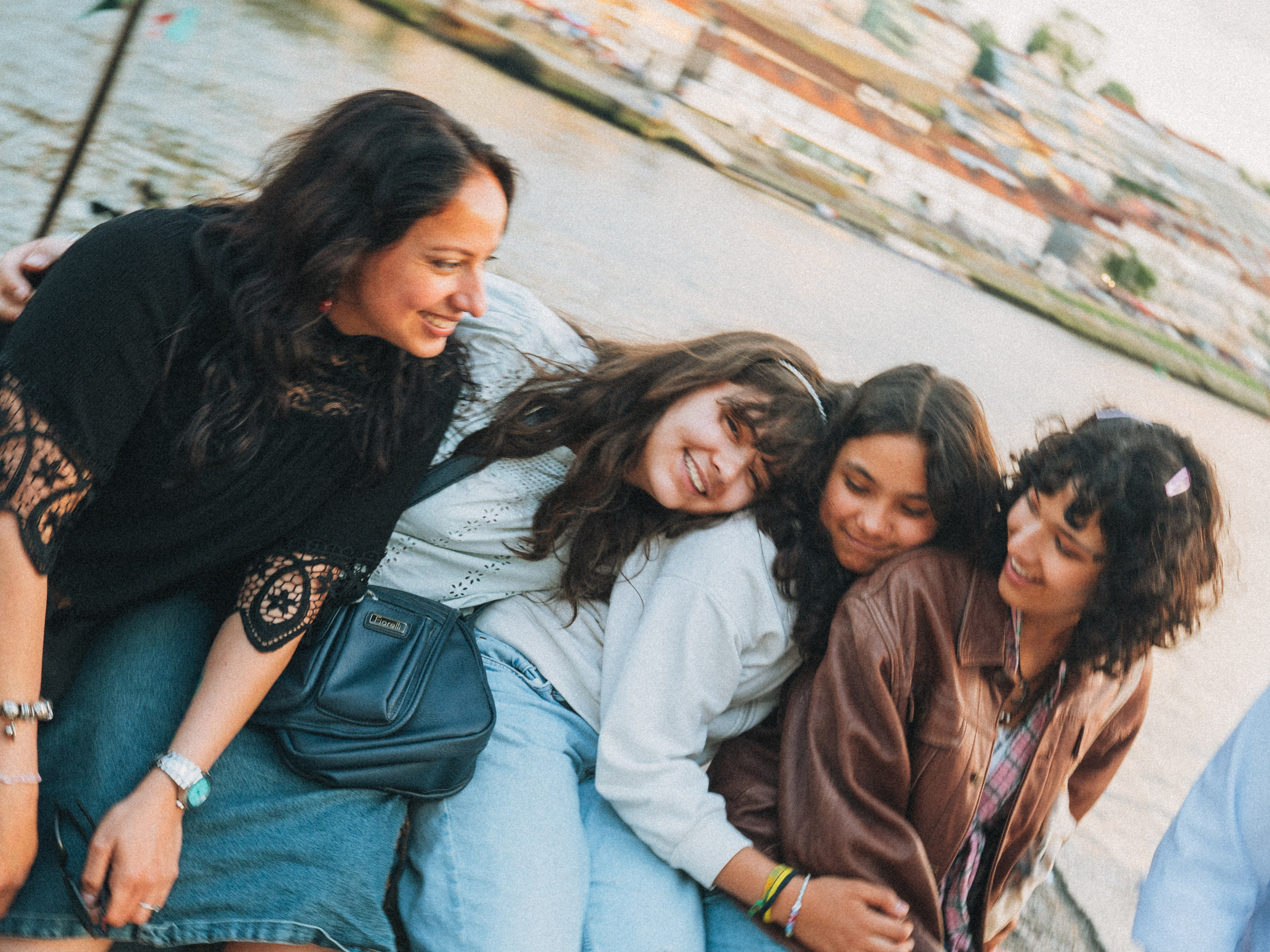 Группа людей семья влюбленные гуляет по живописной узкой улочке в Португалии, окружённой старыми домами и зеленью.