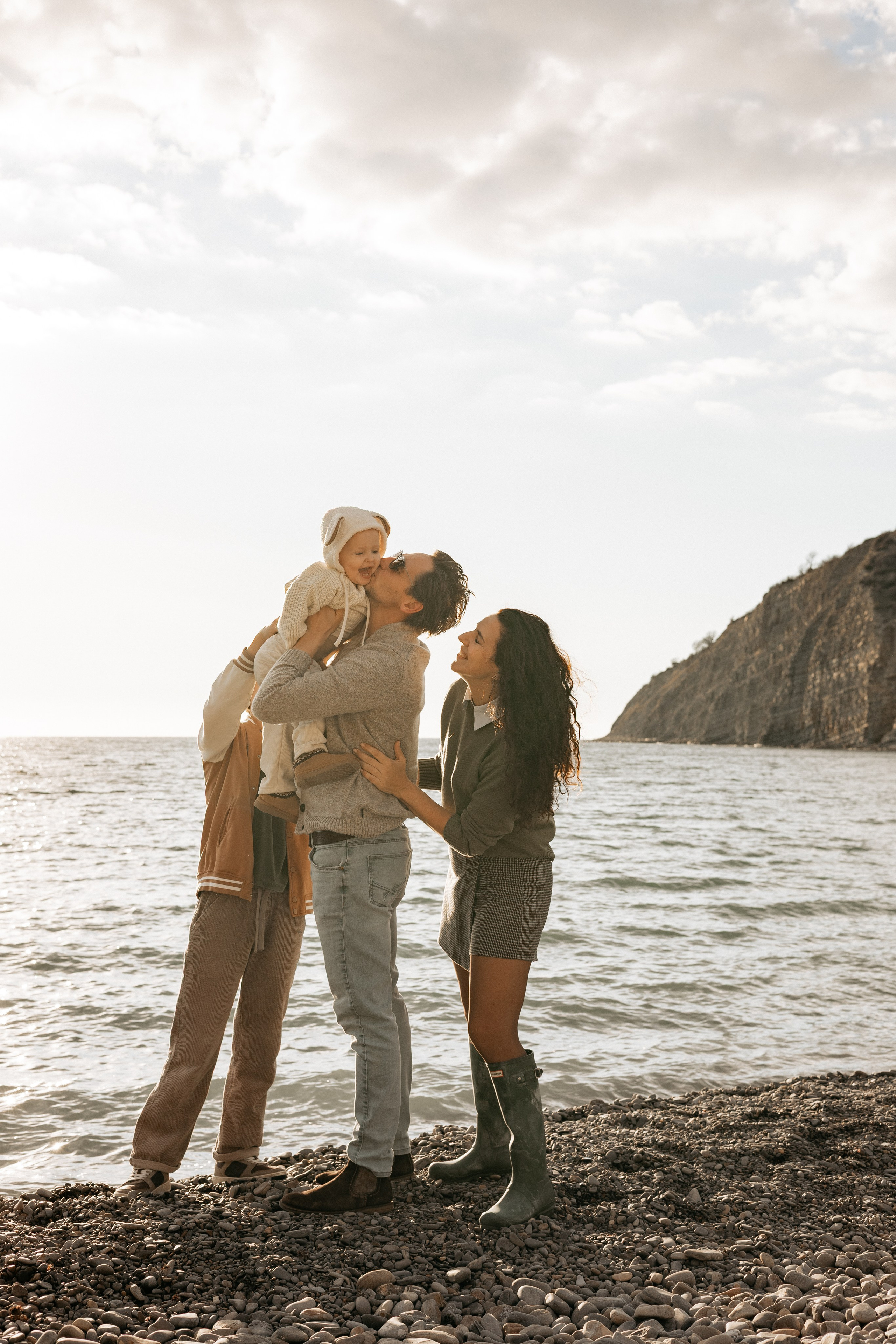 Семейные объятия на фоне золотого морского заката