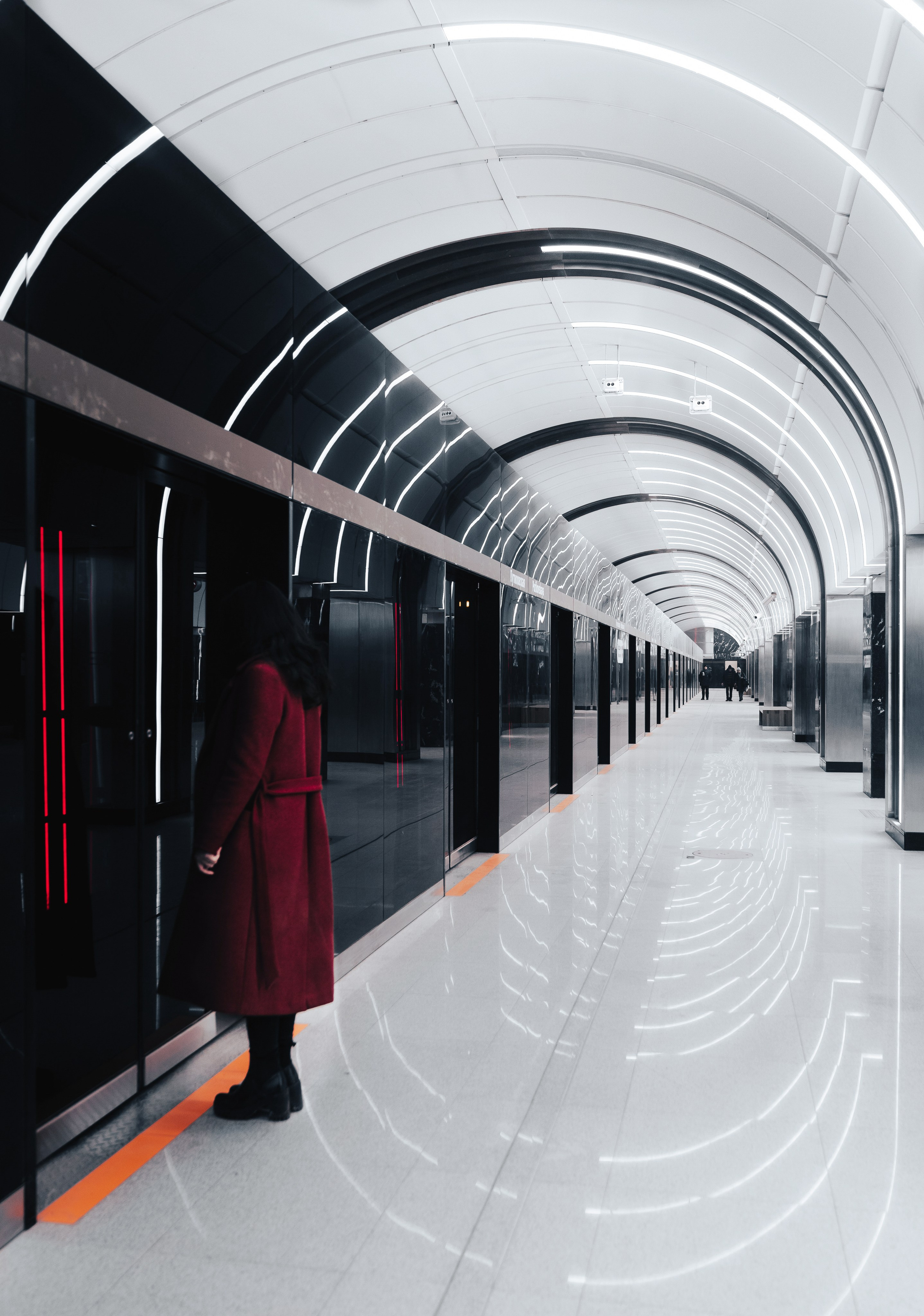 Урбан-фотосессия в метро СПб: девушка в бордовом пальто и чёрных ботинках на фоне мраморных стен и круглых арок, фотограф Евгений Мальцев.