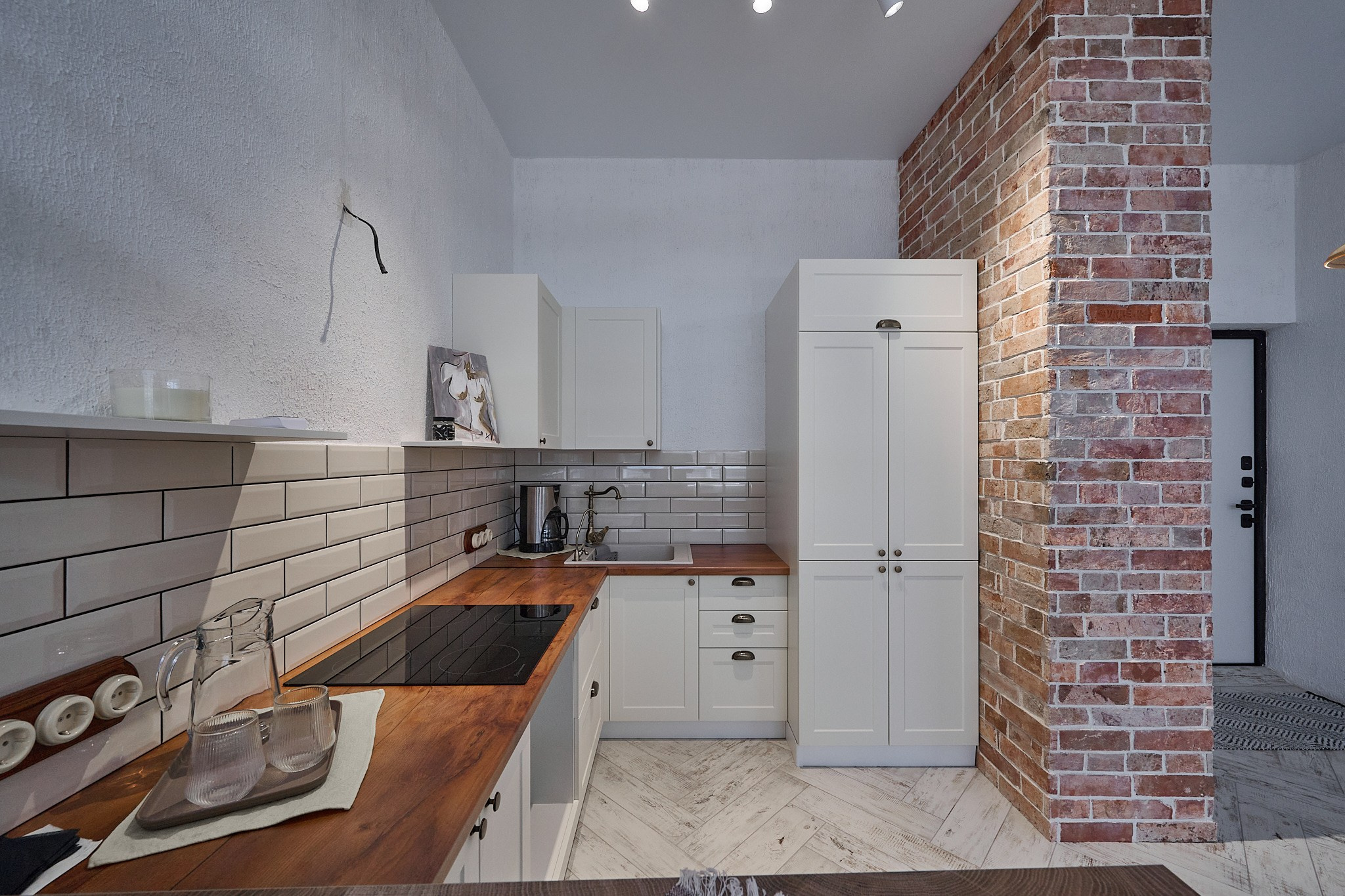 кухня кирпичные стены светлые тонна белые шкафы  коричневая накладка