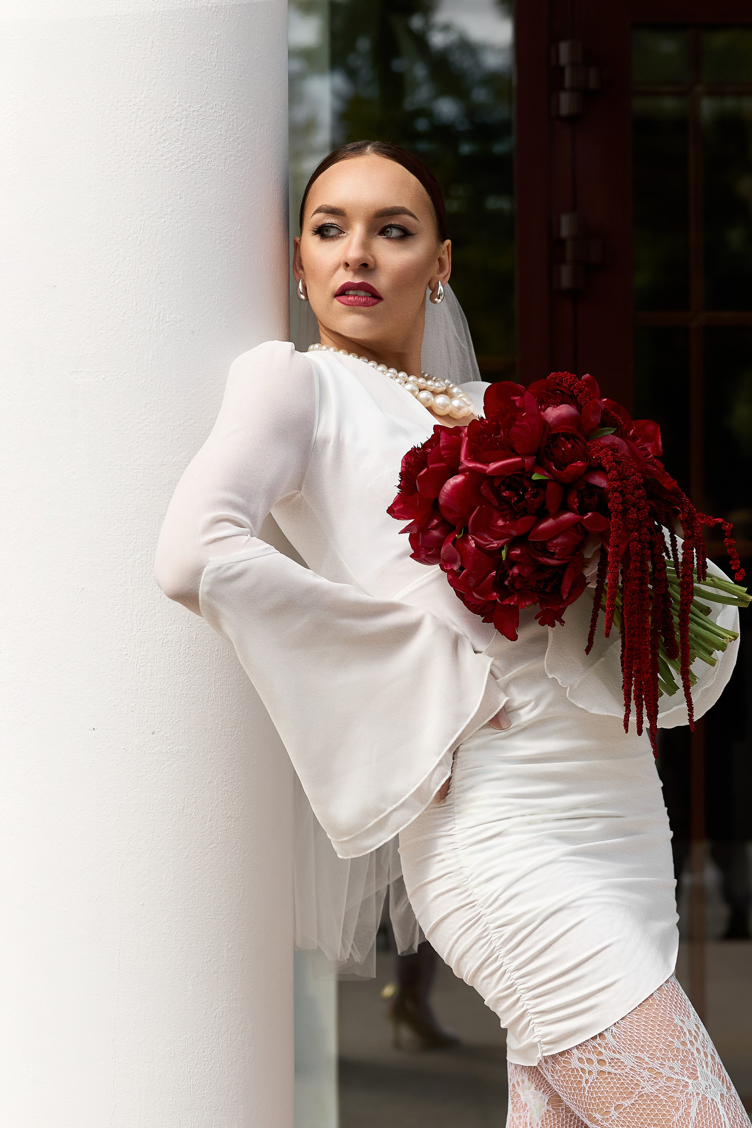 Невеста у колонны театра в Ульяновске с бордовым букетом. Свадебная фотография в классическом стиле. Фотограф Елена Орешина.