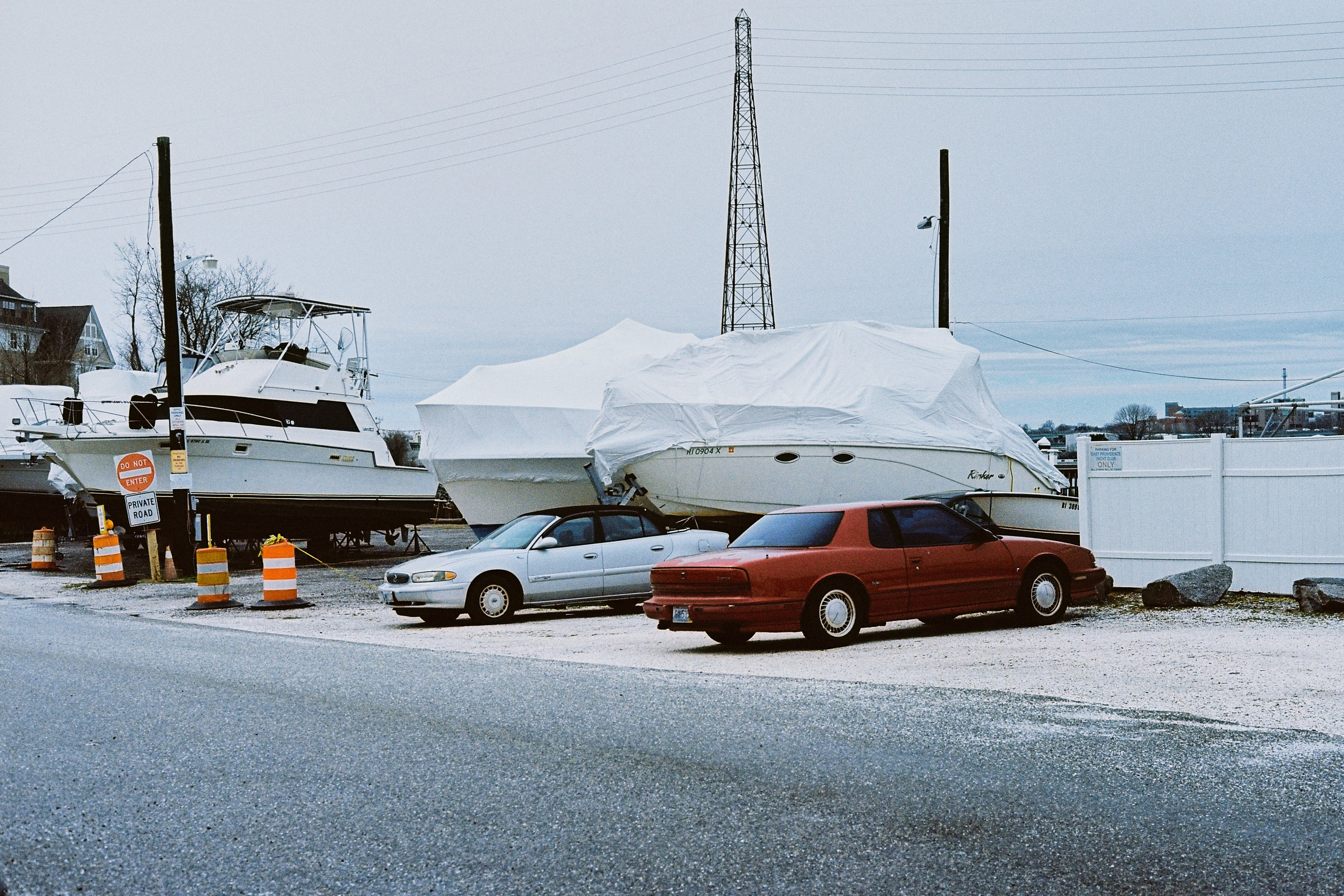 Винтажные авто припаркованы рядом с зачехленными яхтами в яхт клубе, Провиденс, США