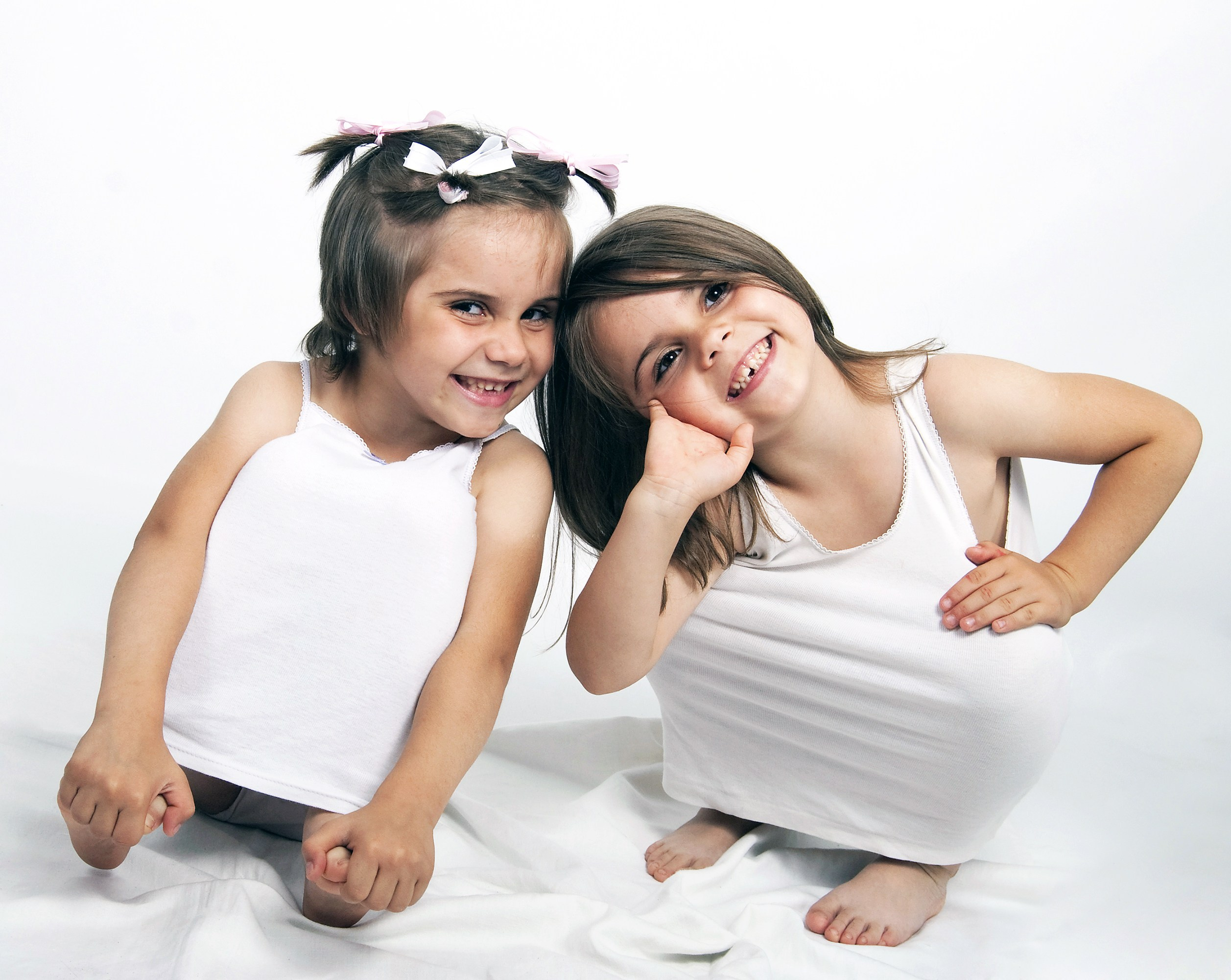 Две счастливые сестрички задорно смеются