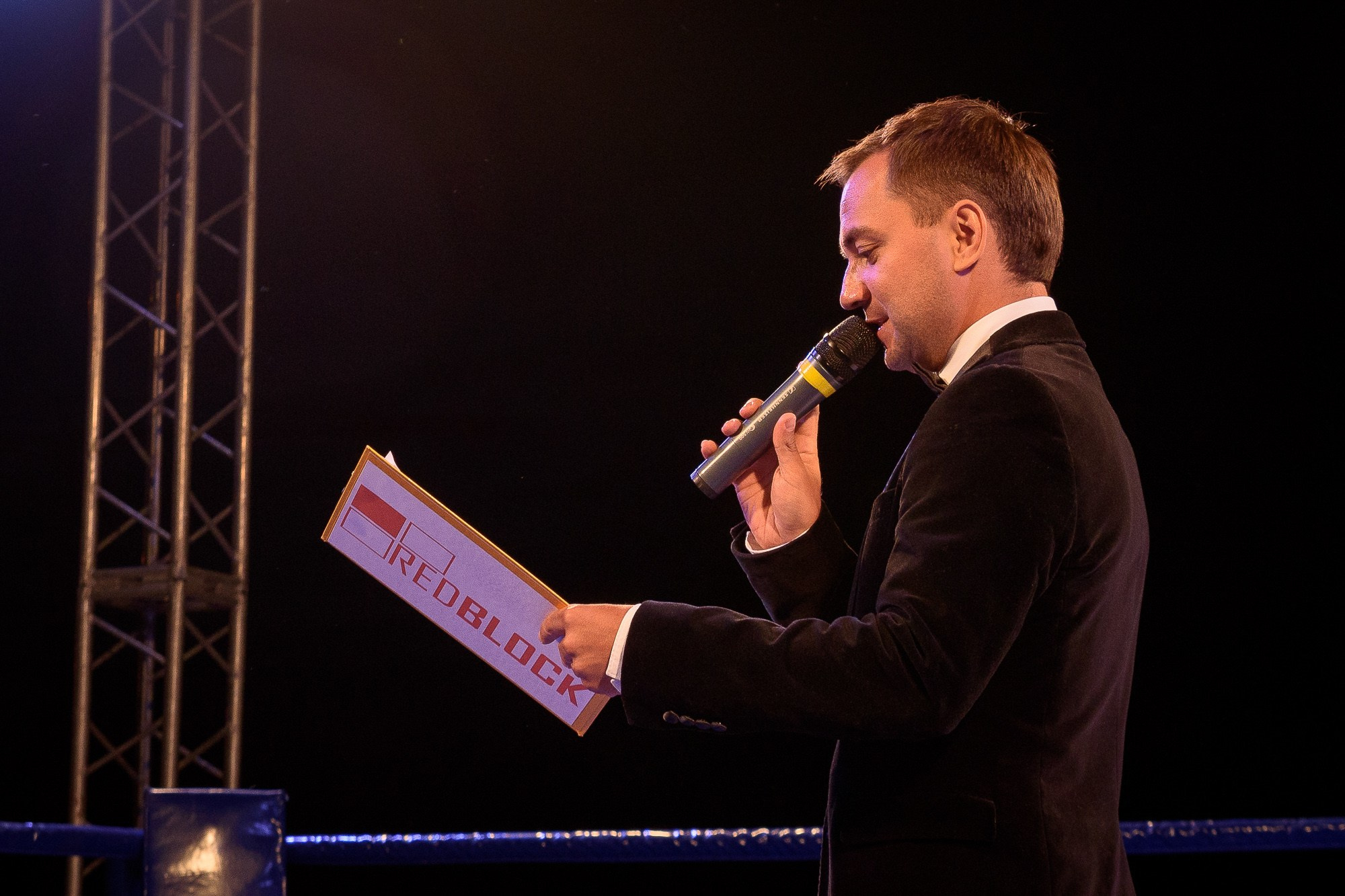 Ведущий мероприятия в черном пиджаке зачитывает состав участников