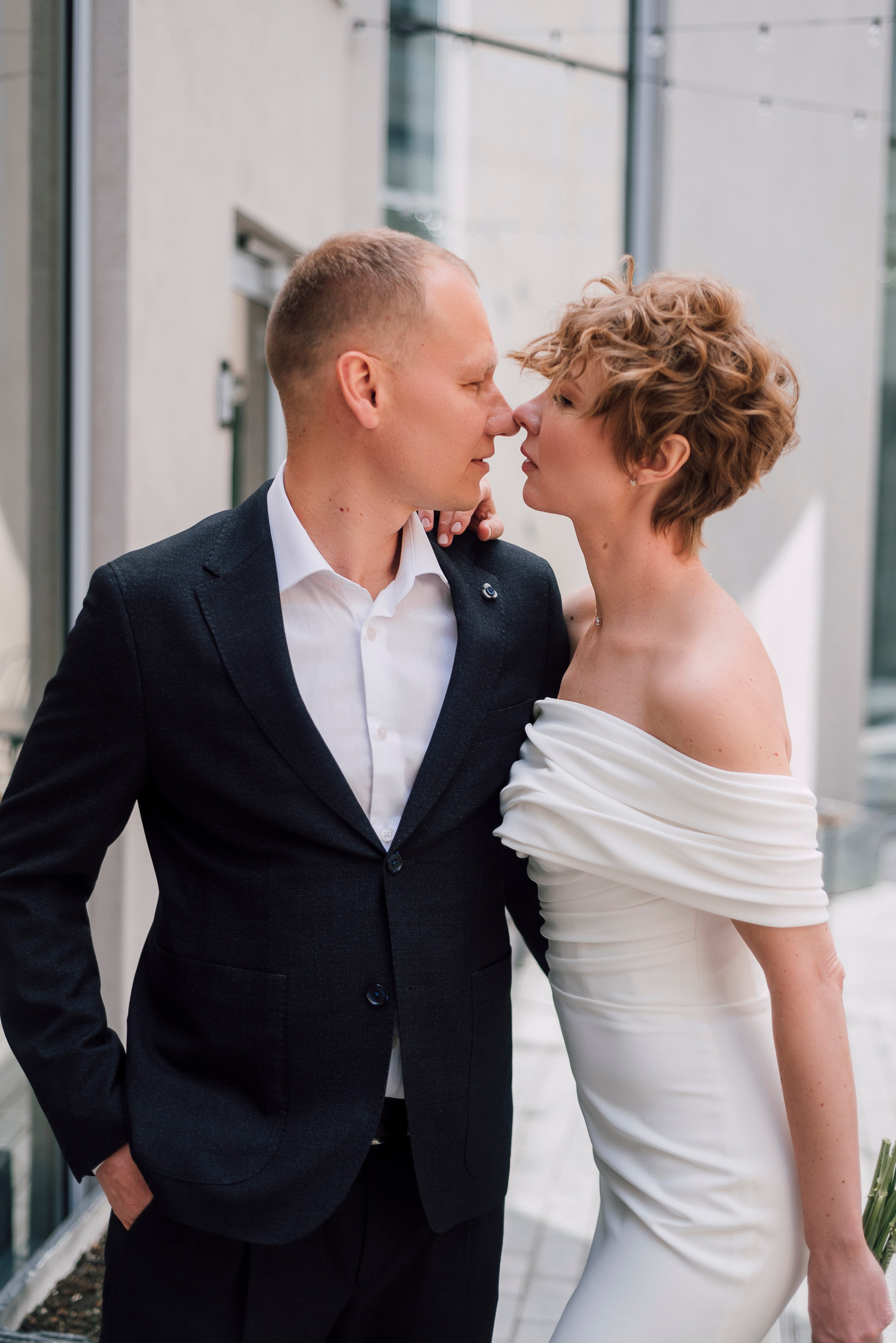 Жених смотрит на невесту на сером фоне