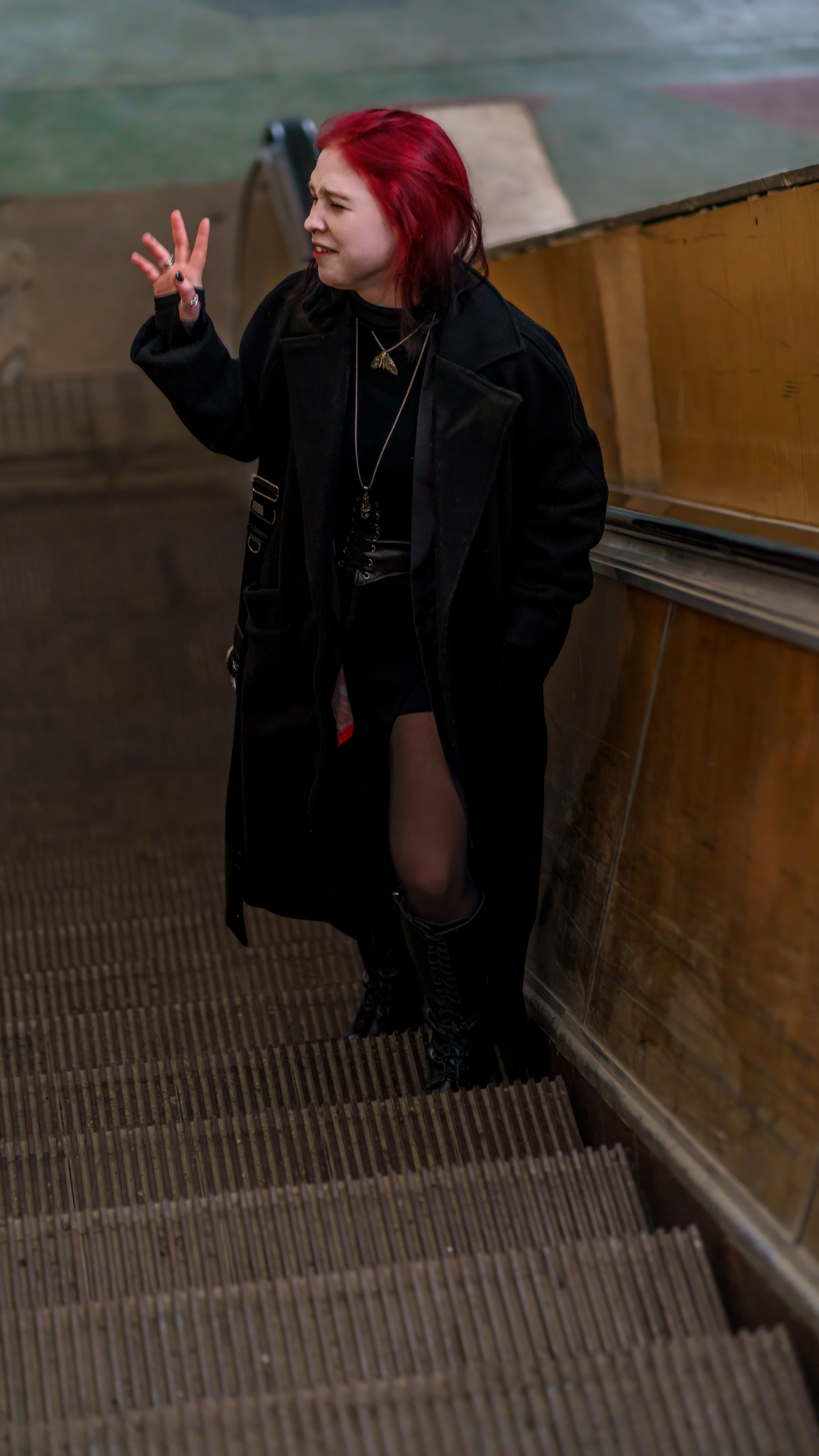 Портрет девушки на эскалаторе, машущей кому-то рукой