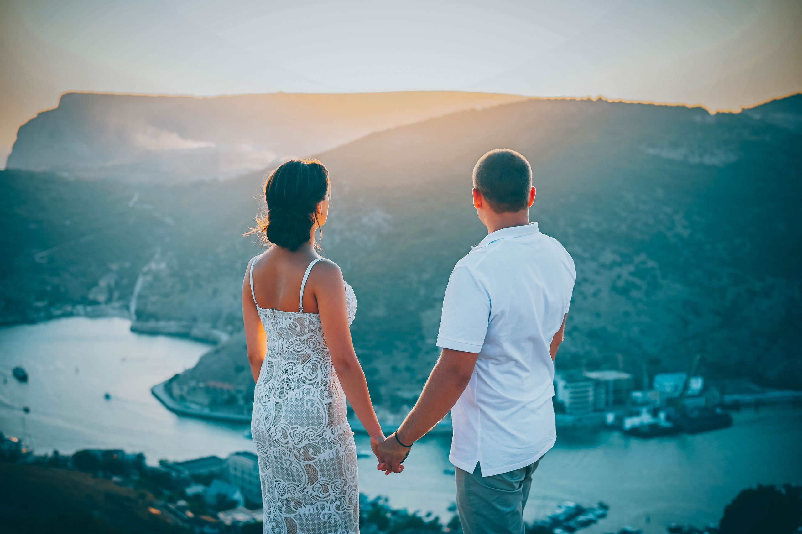 Молодая пара на закате с горы смотрят на бухту в Балаклаве