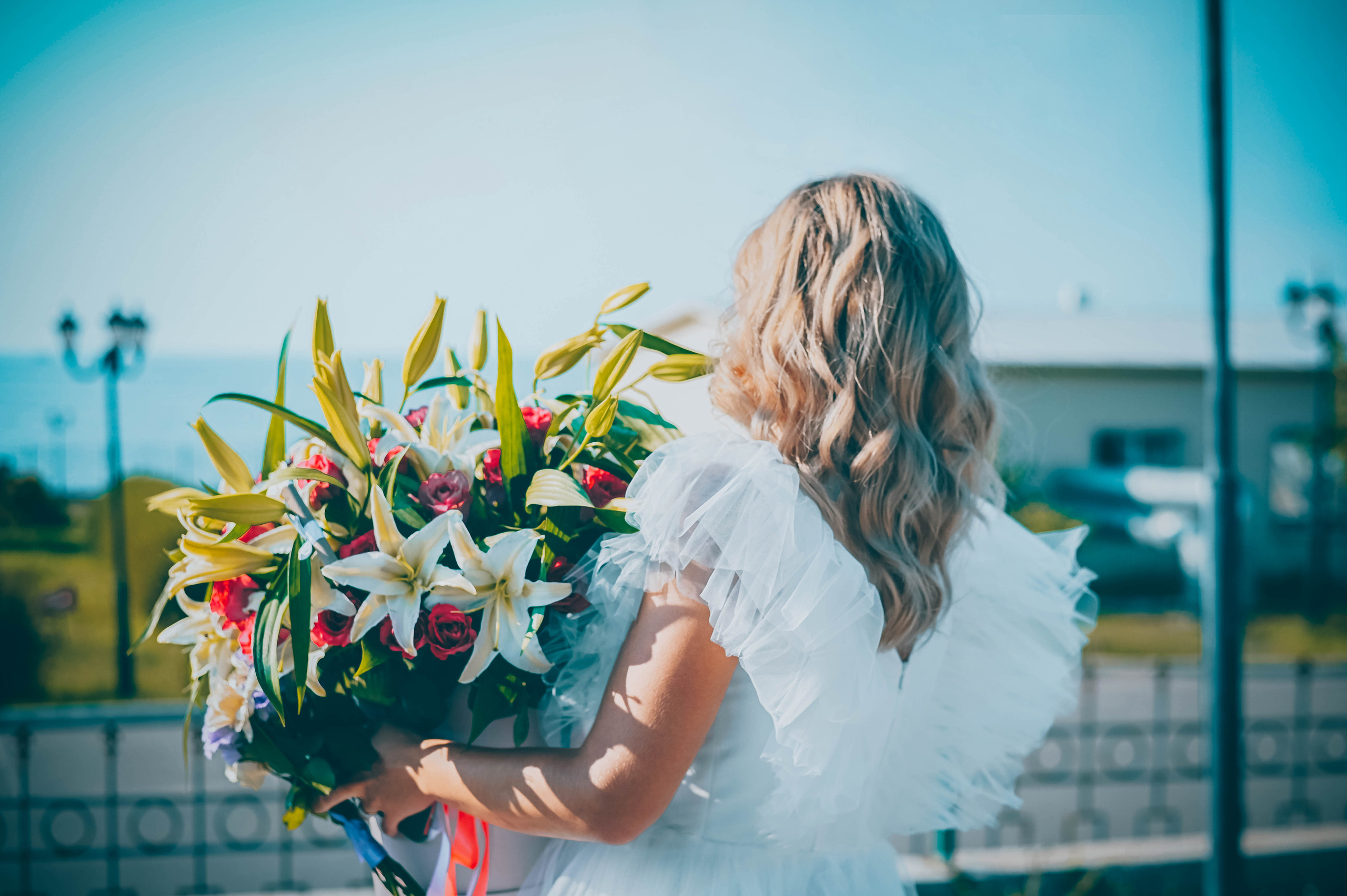 Невеста в белом платье в букетом цветов на торжественном мероприятии