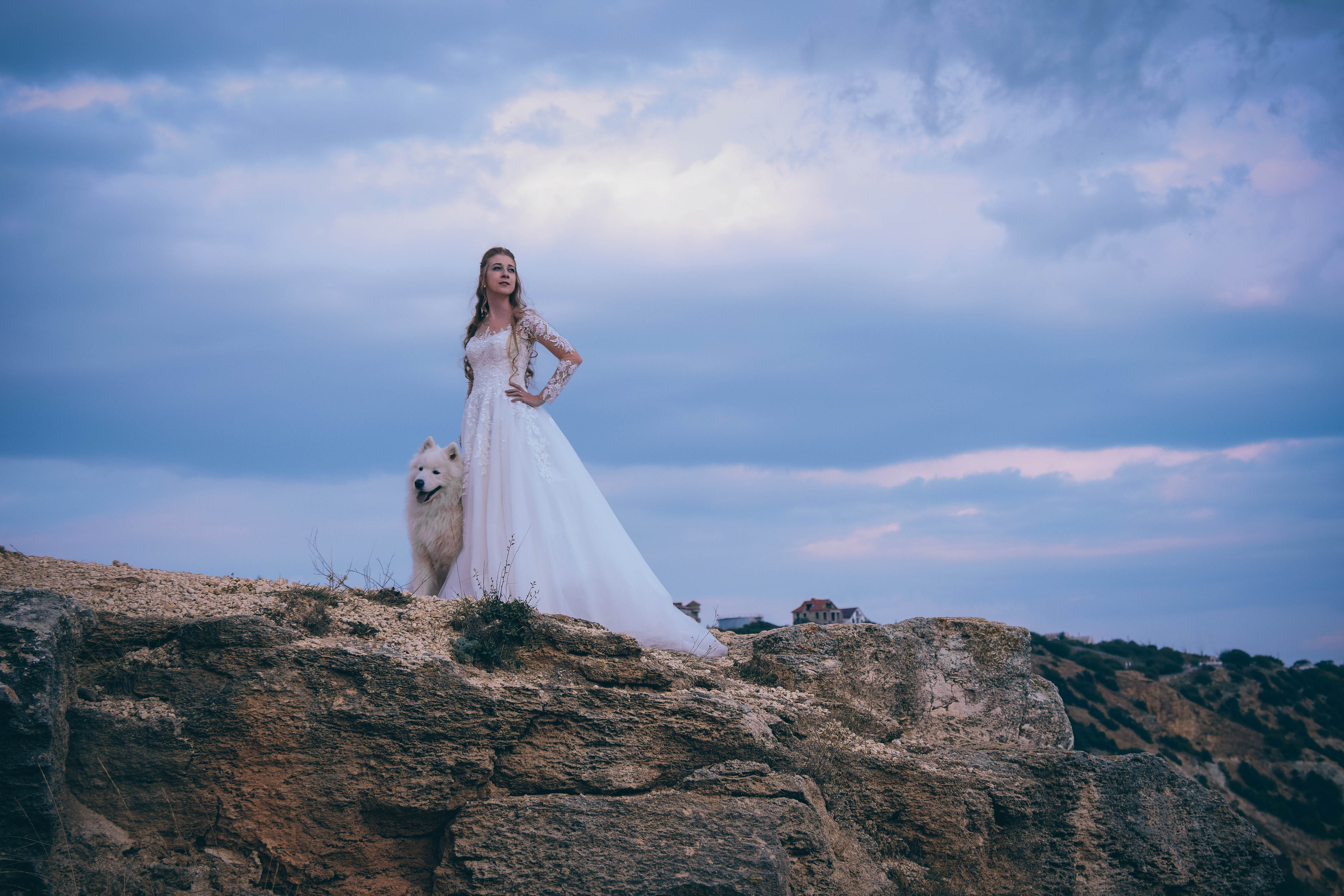 Невеста в белом платье вместе с собакой самоед на мысе Фиолент в Севастополе