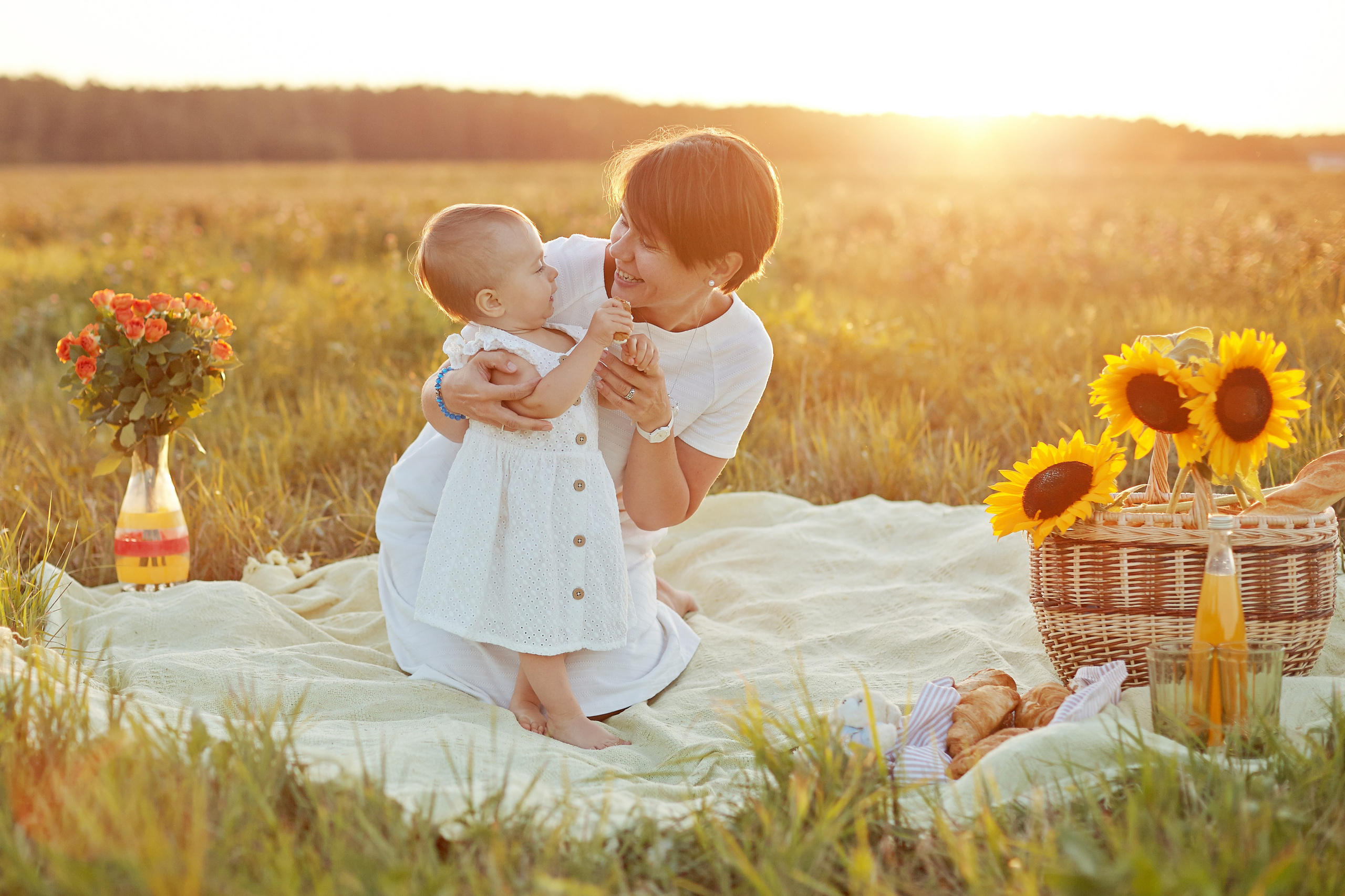 любовь мамы к дочке на фоне закатного света и подсолнухов