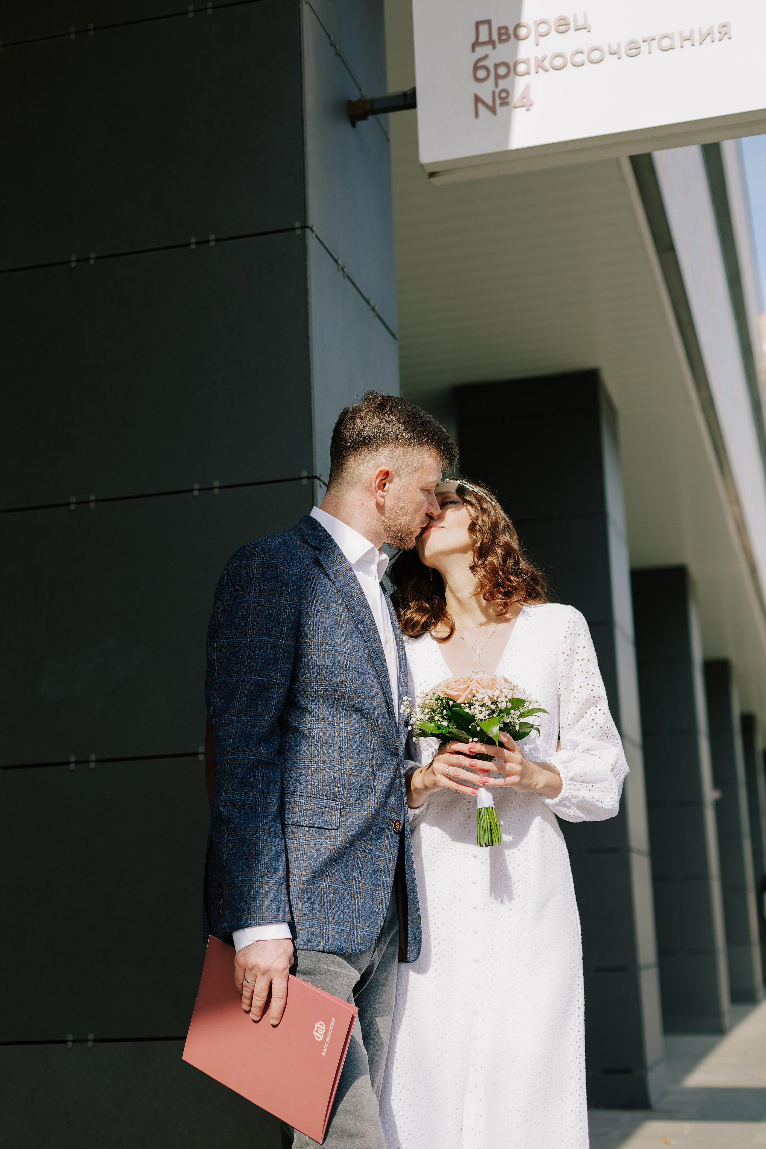 Фотограф в Москве. Молодожены целуются после регистрации в Бутырском ЗАГСе