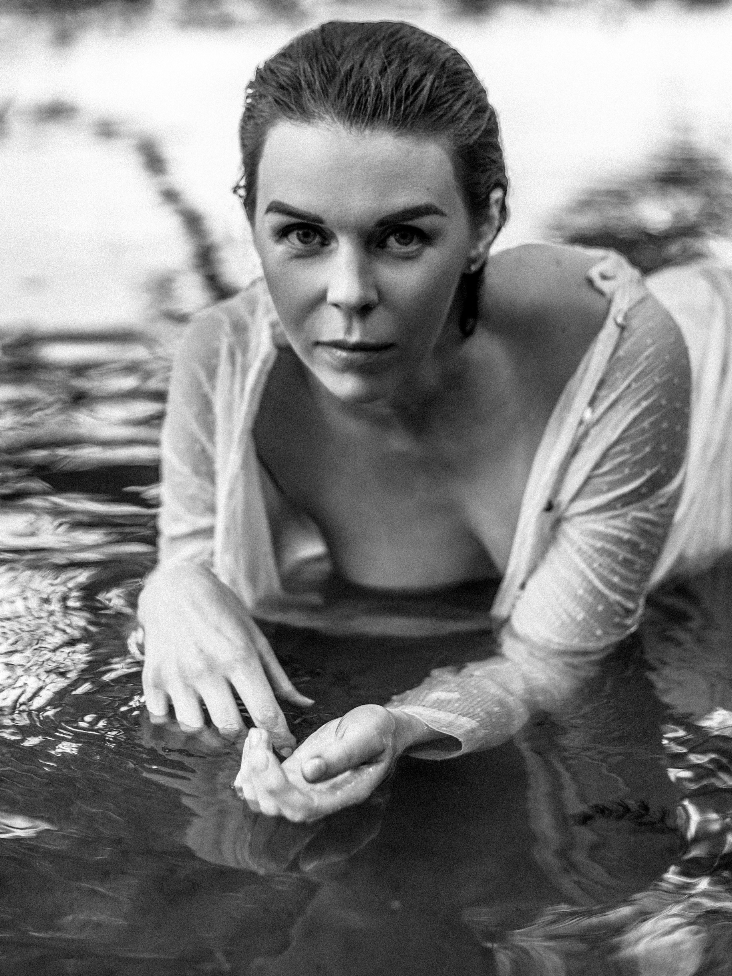 беременная девушка в мокрой белой рубашке в реке чб