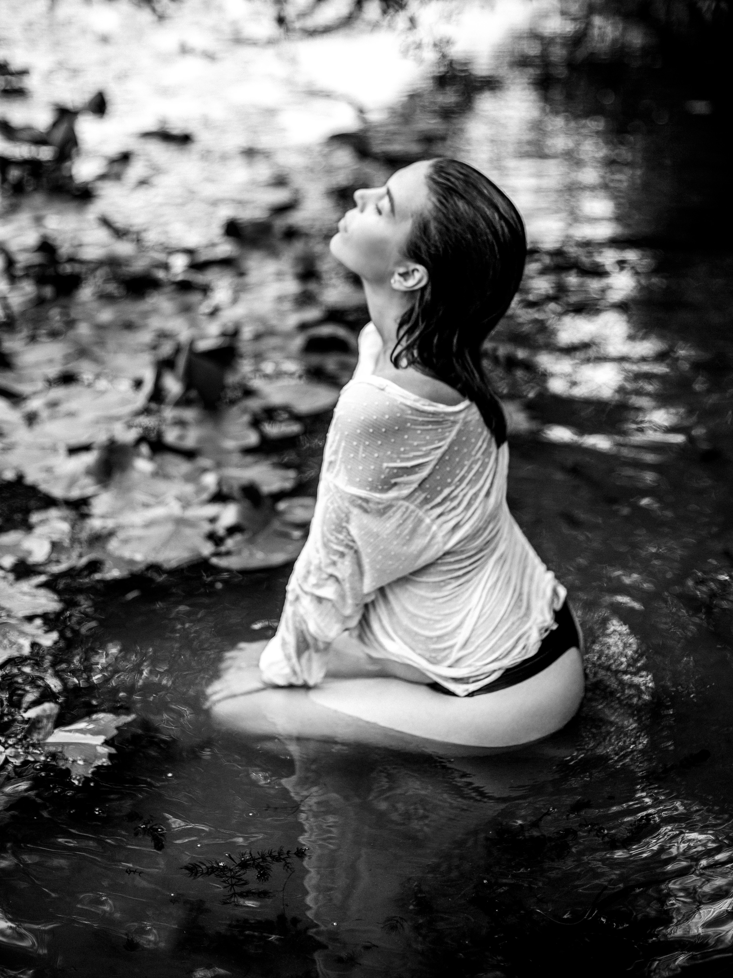 беременная девушка в мокрой белой рубашке в реке чб