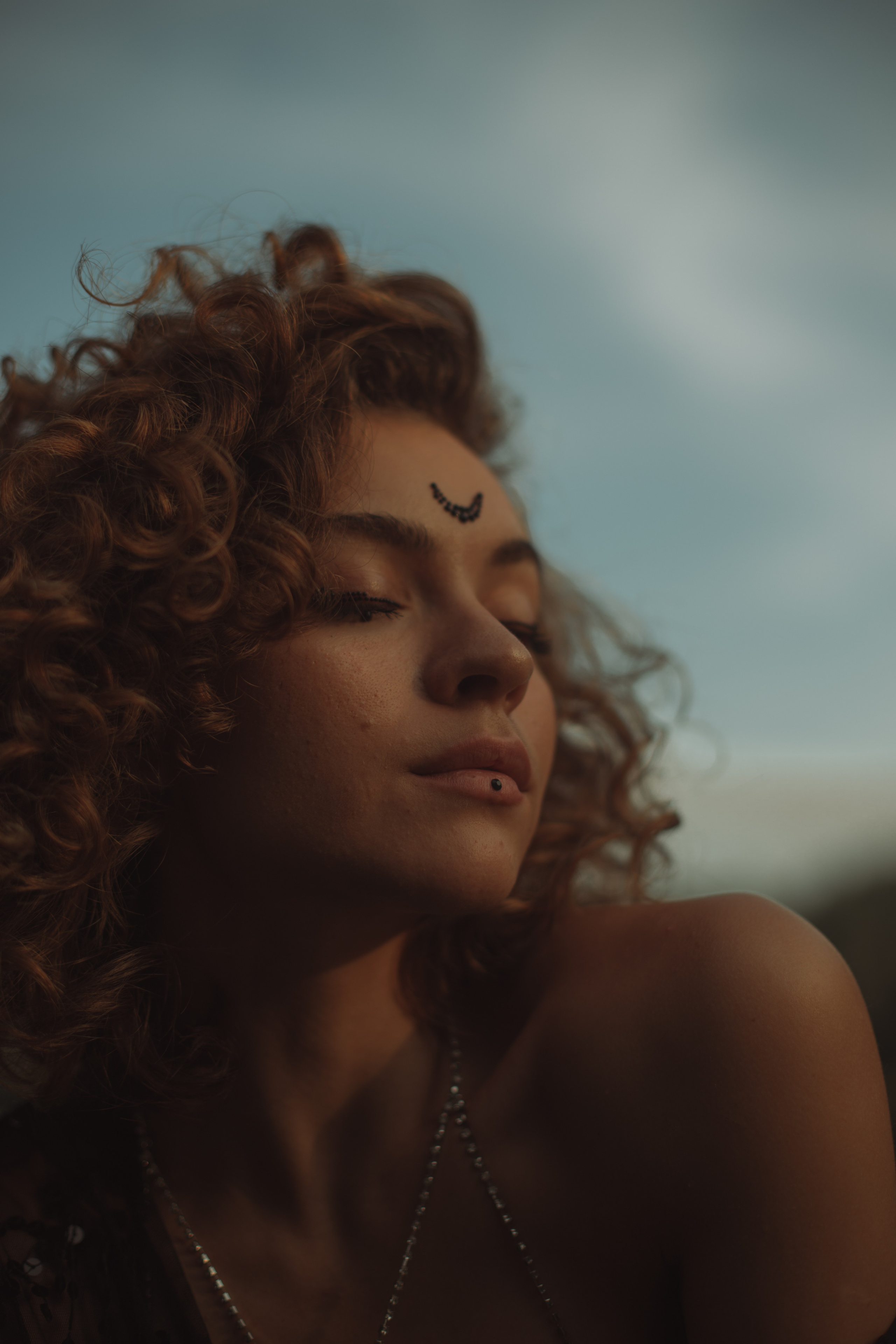 красивая танцующая девушка с рыжими волосами и сверкающим месяцем на лбу