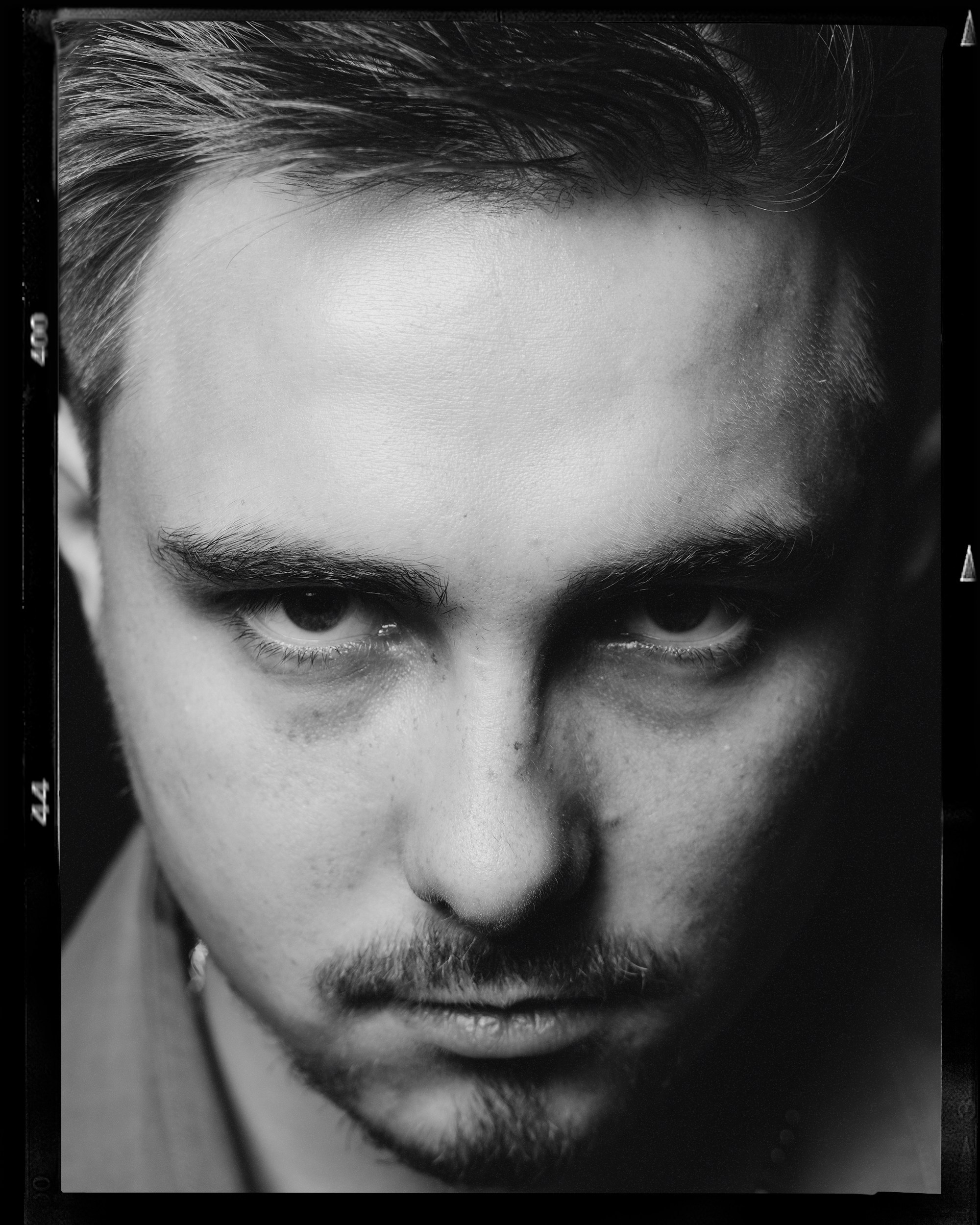 Фотография черно-белая мужика, он смотрит из под лба