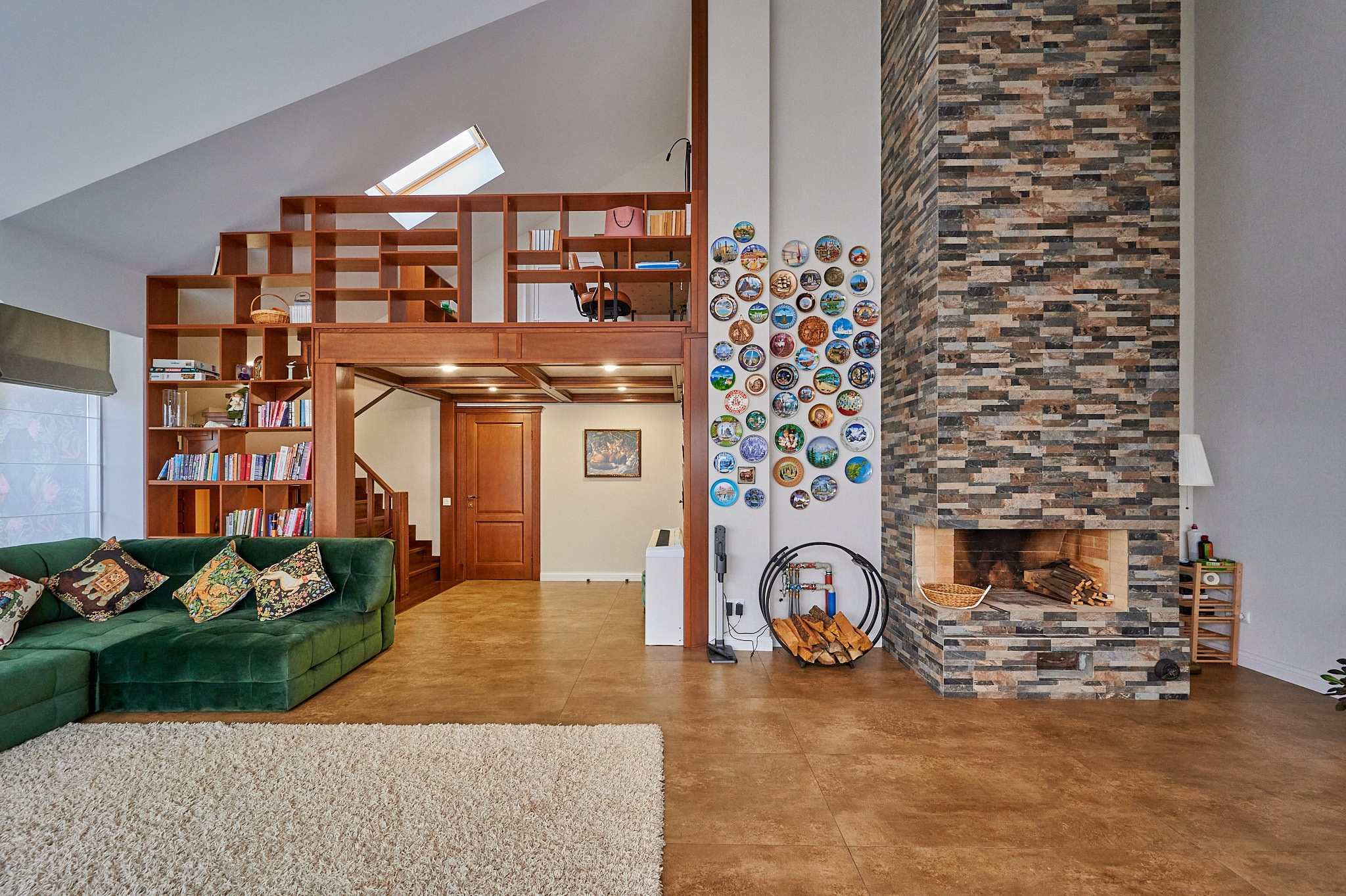 большая комната с камином и деревянным вторым этожем