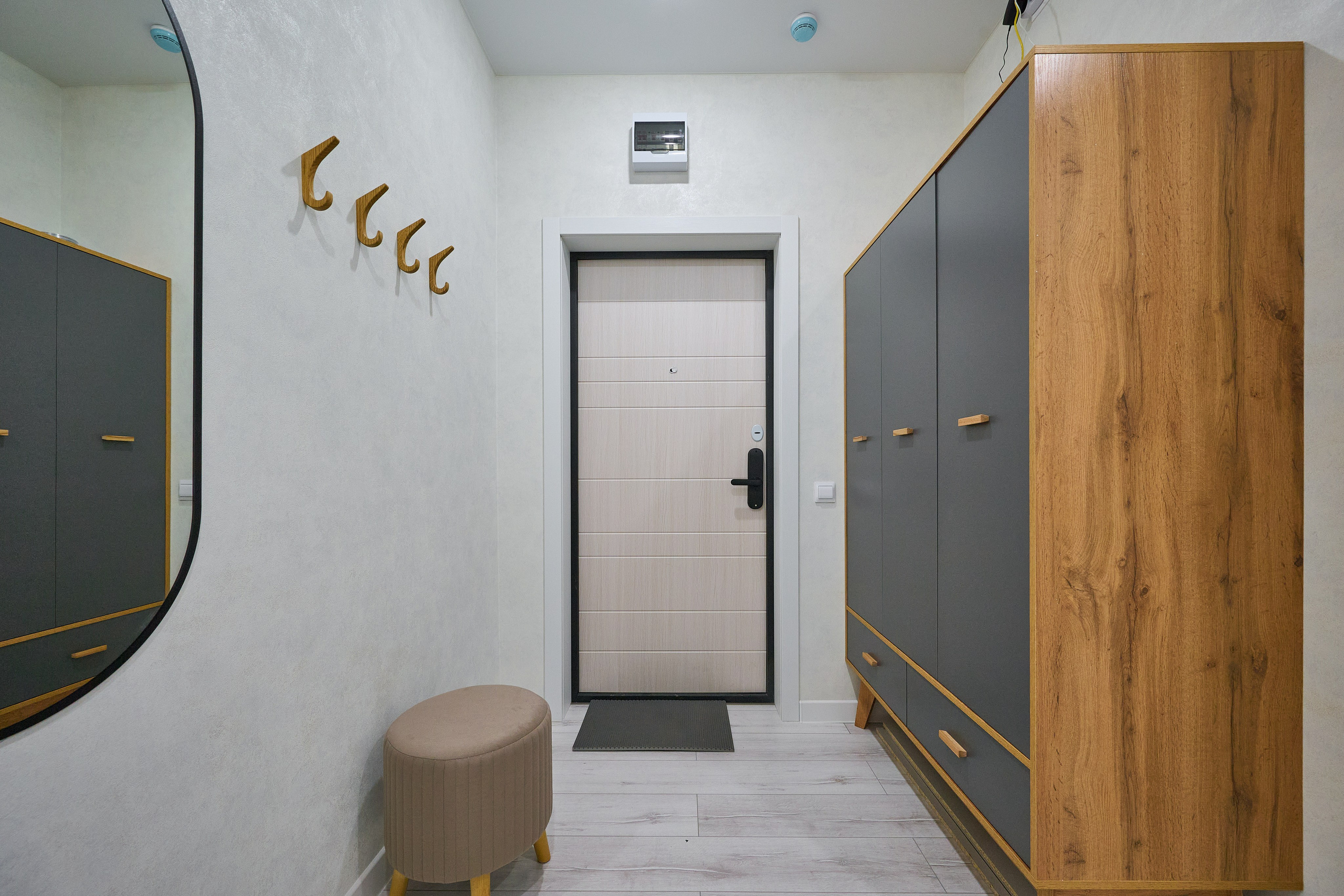 белая входная дверь коридор деревянный черный шкаф бежевый пуфик 