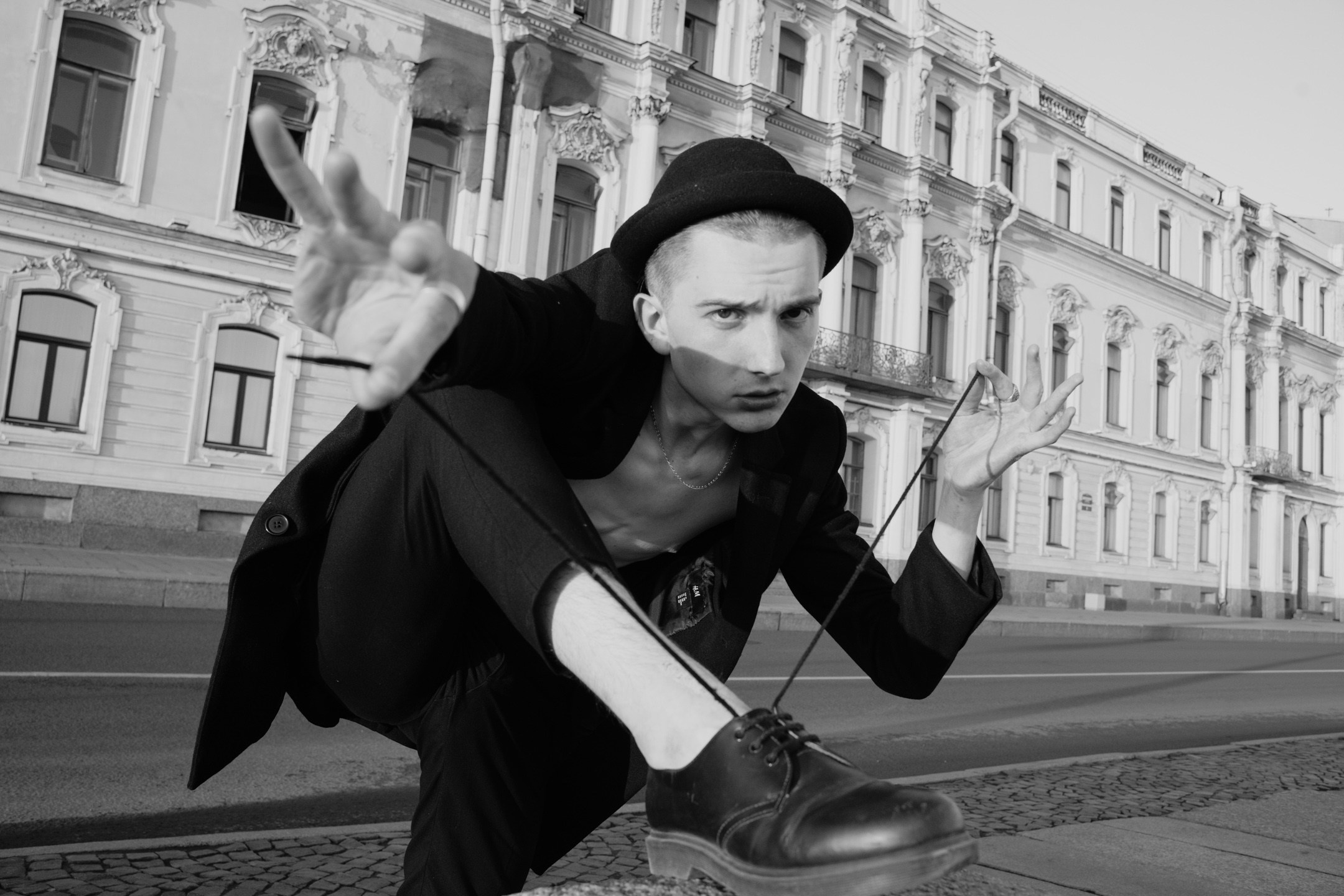 Фотография молодого парня завязывающие шнурки 