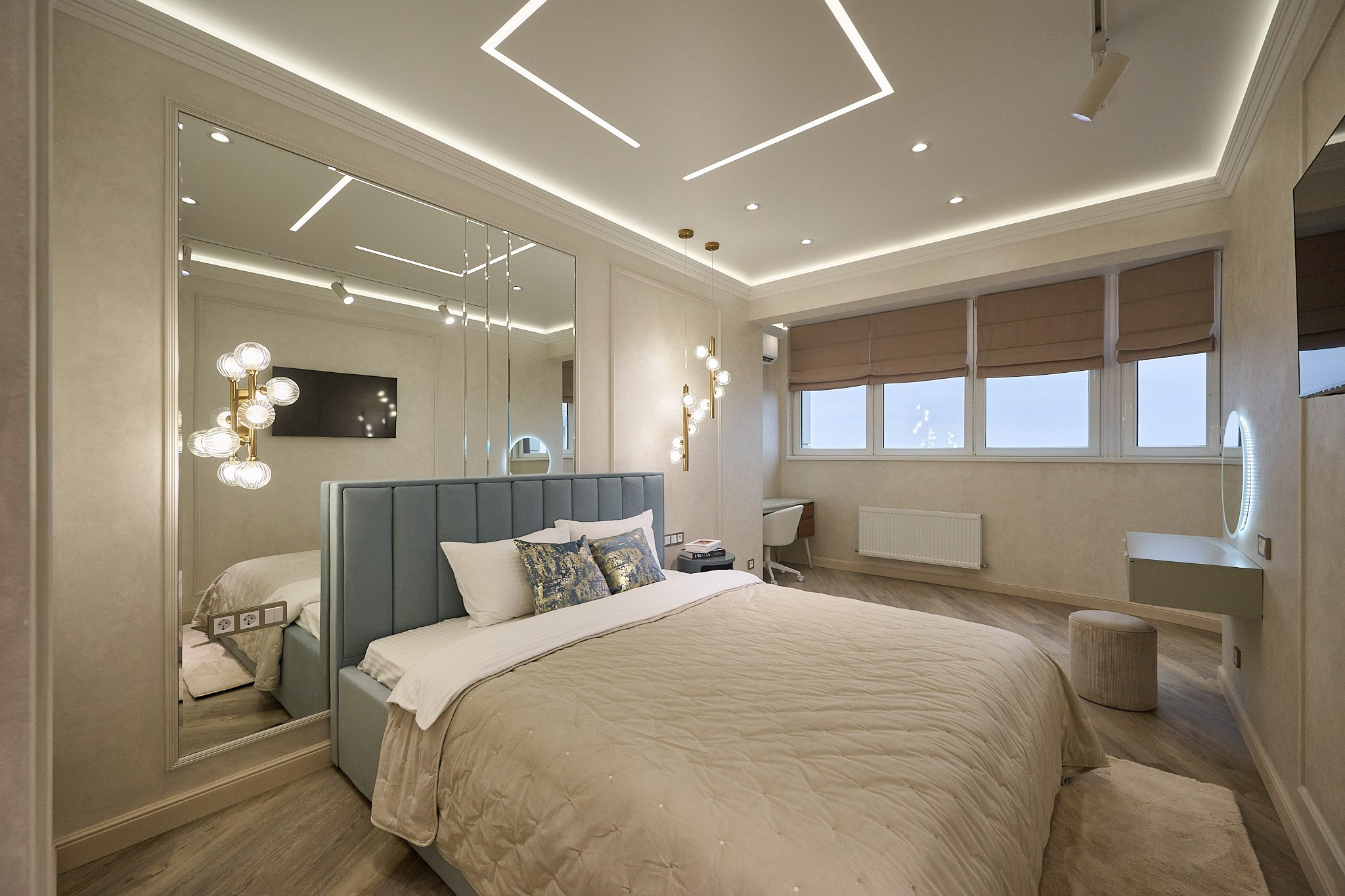 комната в светлых оттенках светло серая кровать большое зеркало телевизор столик с маленьким круглым зеркалом светлый пуфик 