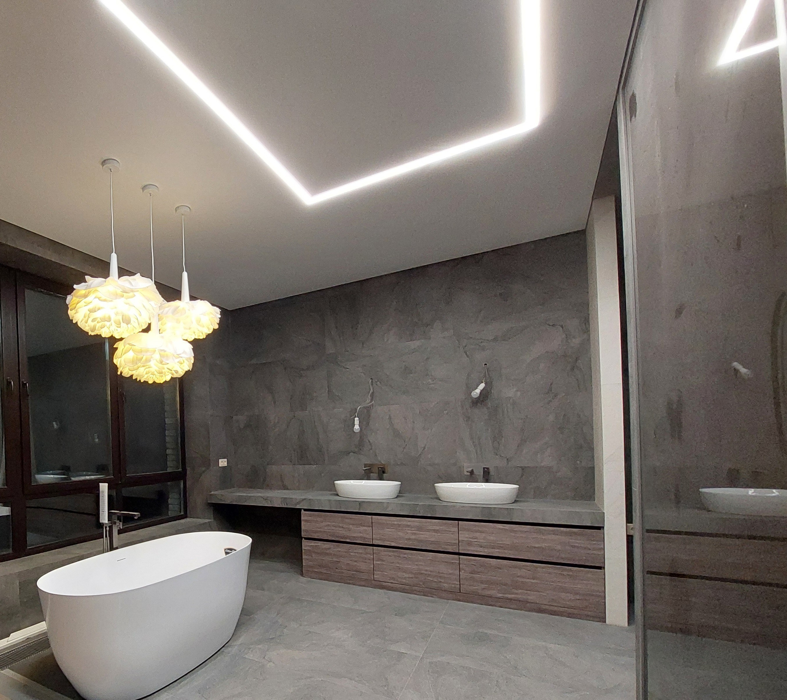 Светодиодные линии в потолке и декоративные люстры создают атмосферу уюта и роскоши.