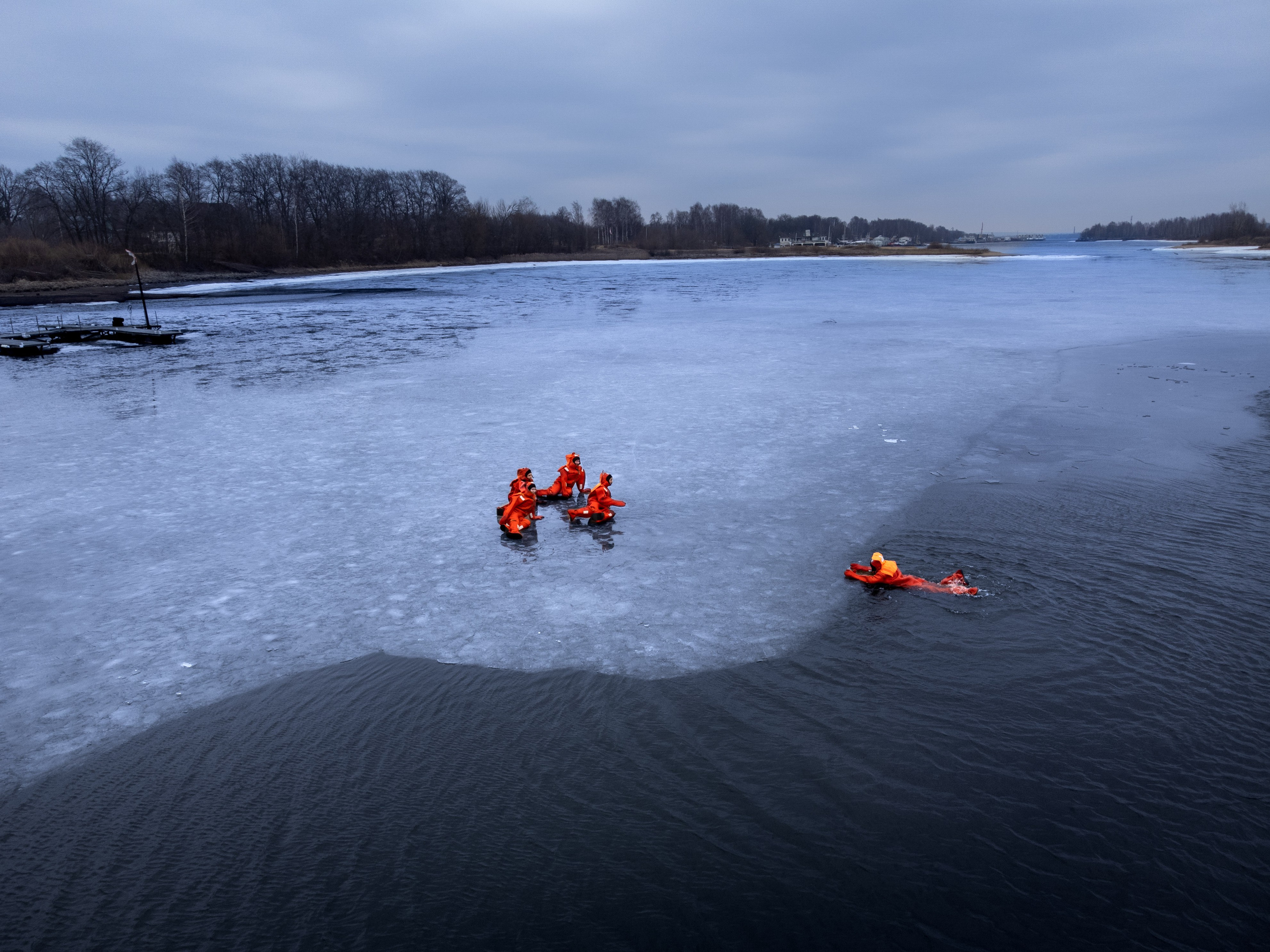 Люди купаются среди льдин, в спасательных оранжевых термо костюмах, айс флоатинг Ярославль