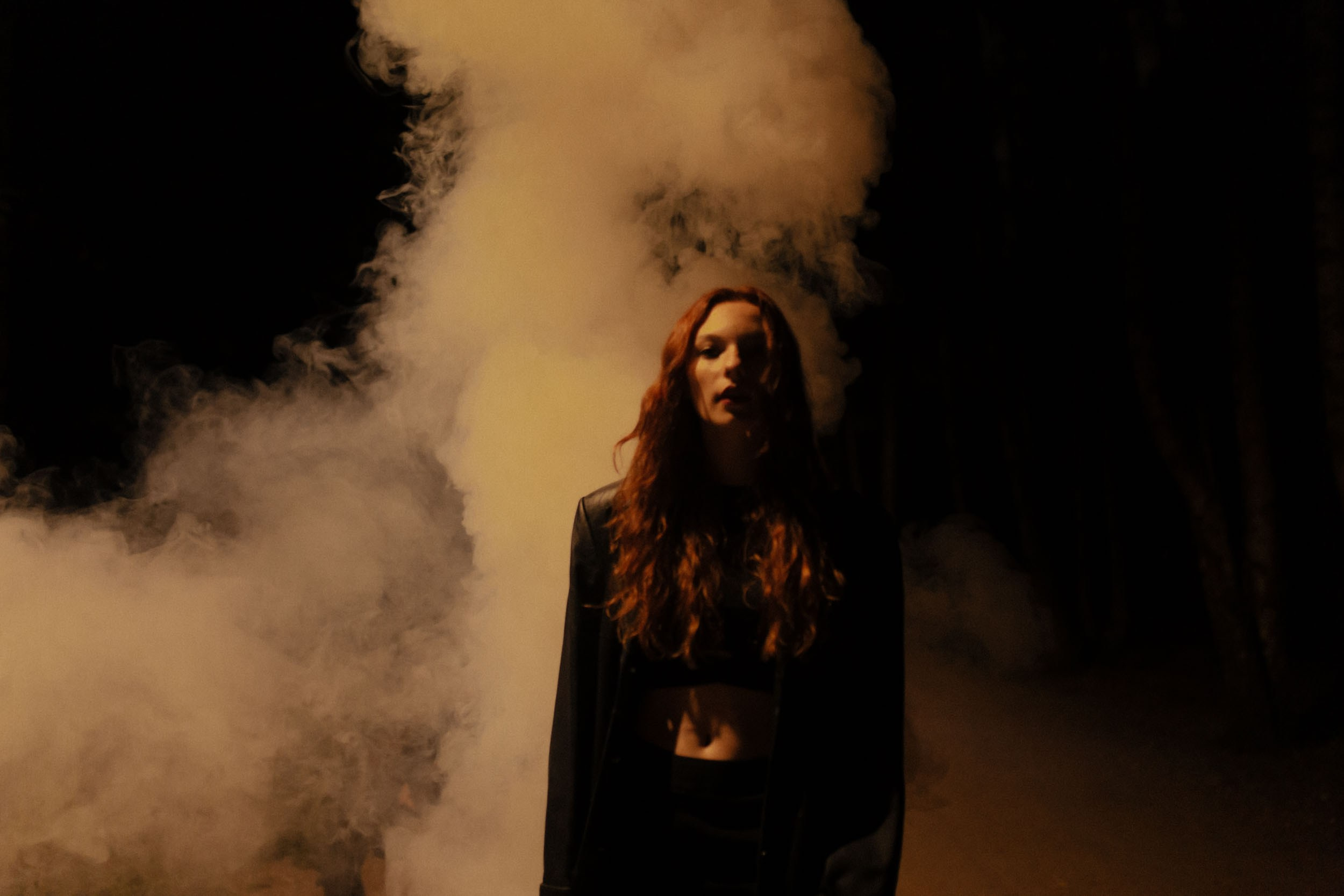 Темный женский силуэт на фоне дыма