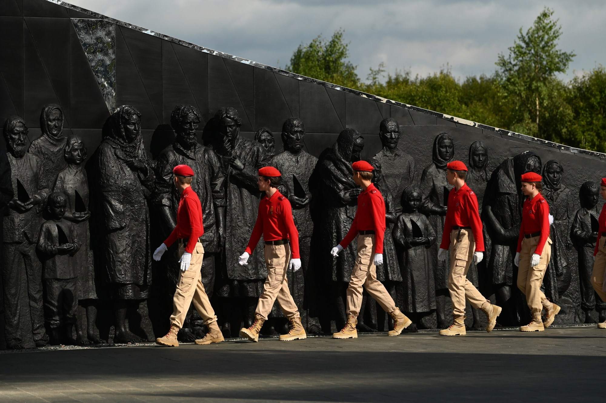 Юнармейцы идут по мемориалу мирным жителям Советского Союза, погибшим в ходе Великой Отечественной войны, перед акцией памяти. Деревня Зайцево, Ленинградская область, 9 августа 2025 года.