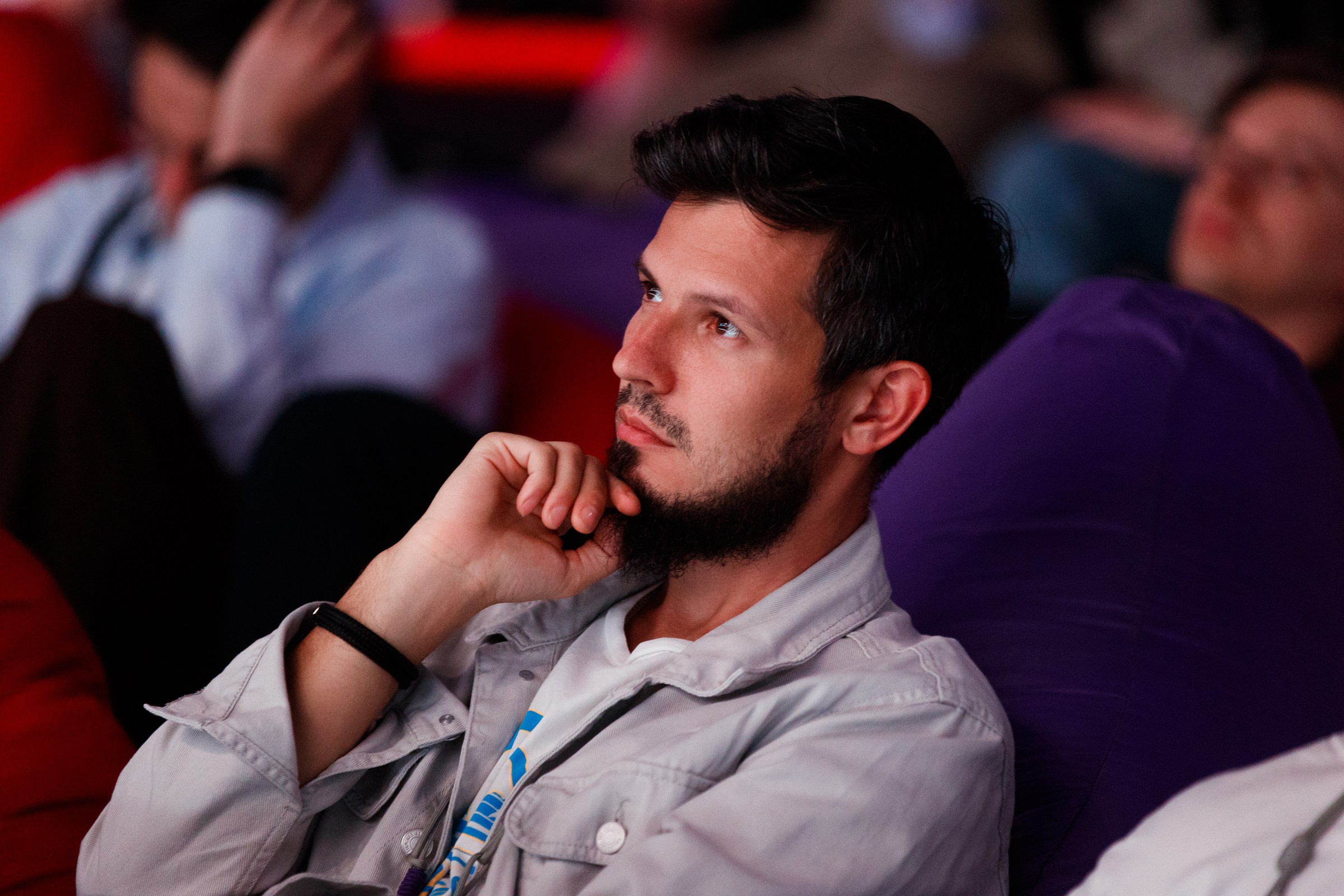 Эмоциональный портрет слушателя в зале, фокус на вовлеченности аудитории во время выступления спикера.