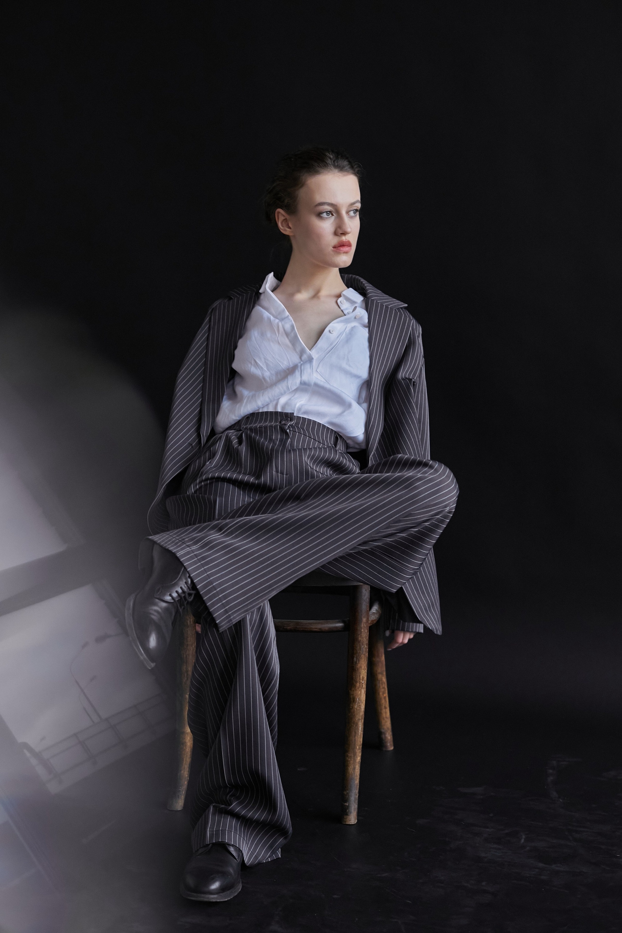 Фотограф в Москве. Студия. Студийный портрет. Девушка в пиджаке. Девушка на стуле на черном фоне. Красивая девушка в мужском костюме. Женский портрет.