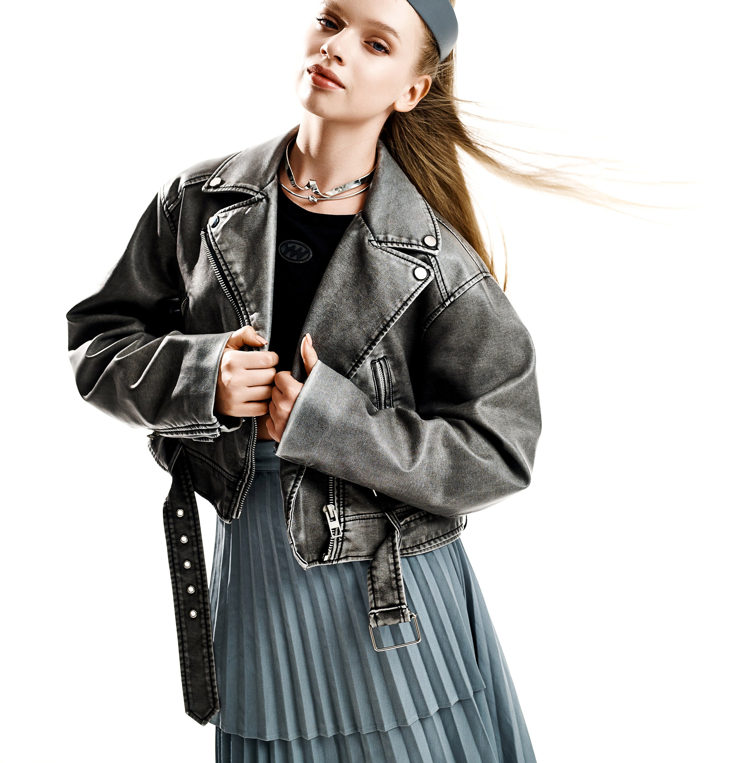 Девушка модель в серой кожаной куртке косухе и синей юбке